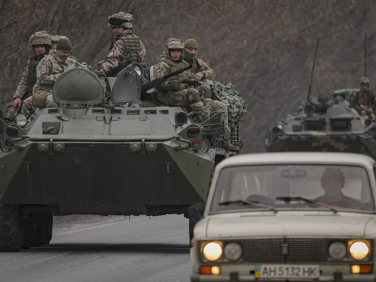 Ukrainian servicemen sit atop armored personnel
carriers driving on a road in the Donetsk region, eastern Ukraine,
Thursday. Russian President Vladimir Putin on
Thursday announced a military operation in Ukraine and warned other
countries that any attempt to interfere with the Russian action
would lead to "consequences you have never seen.”