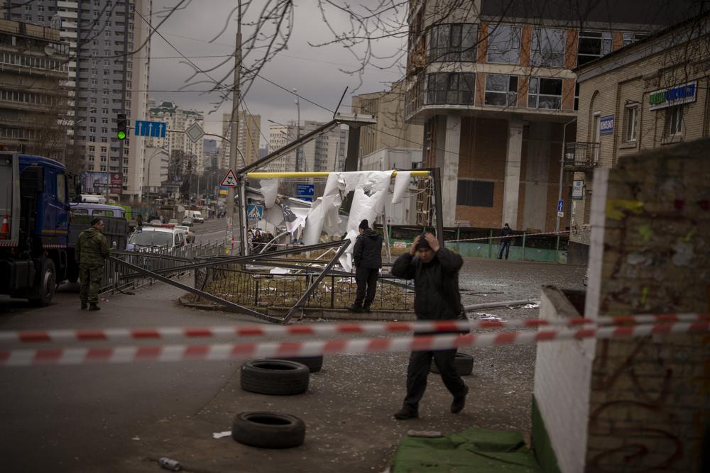 Police officers inspect area after an apparent Russian strike in Kyiv Ukraine, Thursday. Russian President Vladimir Putin on Thursday announced a military operation in Ukraine and warned other countries that any attempt to interfere with the Russian action would lead to "consequences you have never seen."
