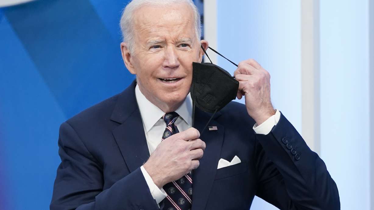 President Joe Biden removes his face mask to speak in the South Court Auditorium in the Eisenhower Executive Office Building on the White House complex, Tuesday in Washington.
