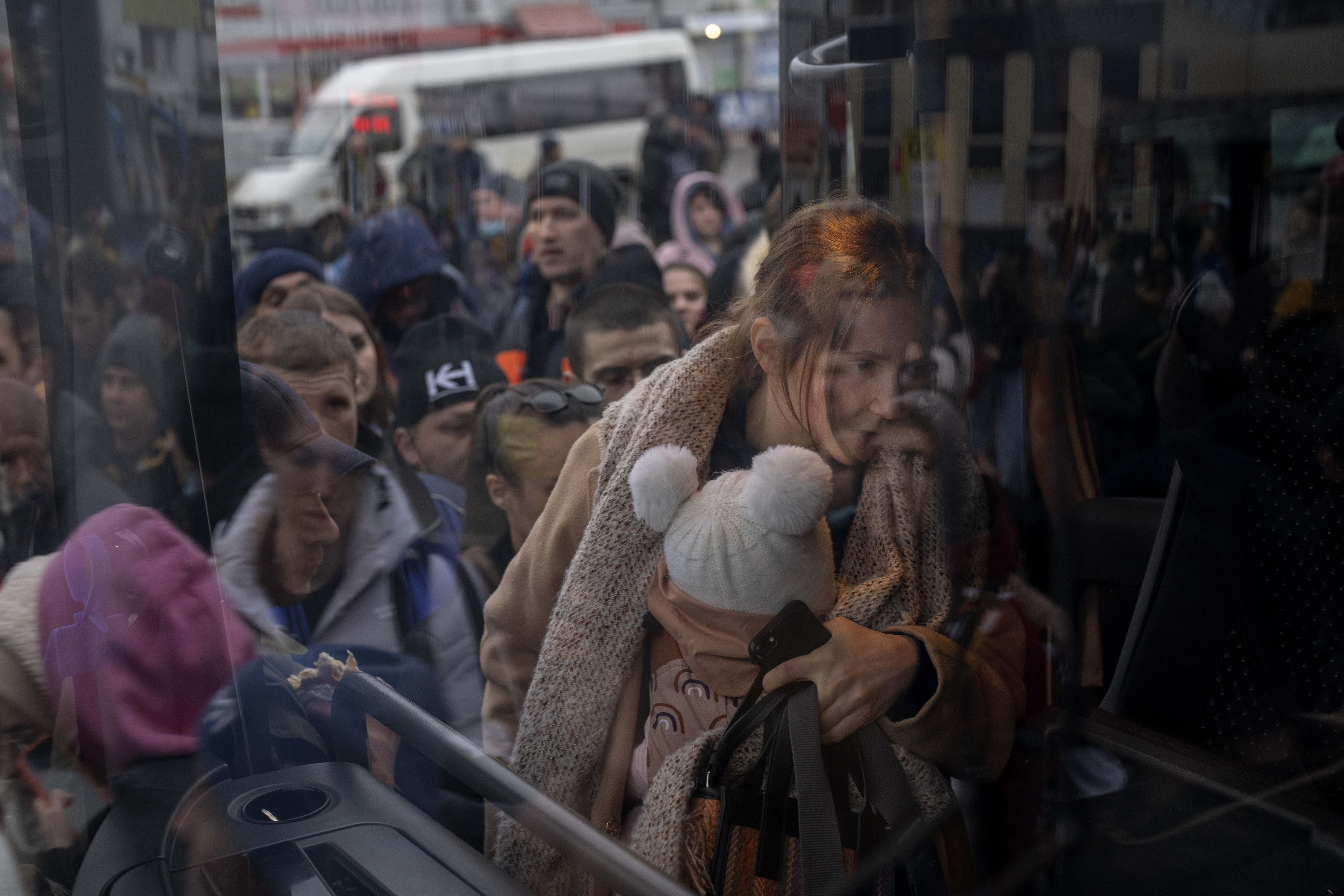 A woman holds her baby as she gets on a bus leaving Kyiv, Ukraine, Thursday. A local organization is organizing help for Ukraine, giving Utahns and those with friends and family in Ukraine a way to help, half a world away.