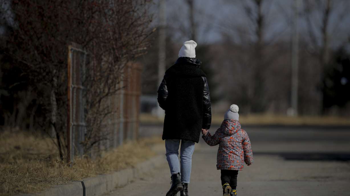 A woman holds a child's hand after crossing the border from Ukraine at the Romanian-Ukrainian border, in Siret, Romania, Friday. Thousands of Ukrainians are fleeing from war by crossing their borders to the west in search of safety.