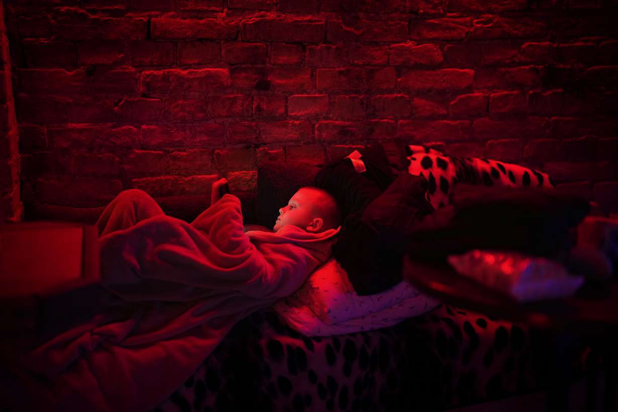 Svyatoslav, 6, plays with his tablet in a public basement used as a bomb shelter in Kyiv, Ukraine, Thursday, Feb. 24, 2022. Russia has launched a full-scale invasion of Ukraine, unleashing airstrikes on cities and military bases and sending troops and tanks from multiple directions in a move that could rewrite the world's geopolitical landscape.