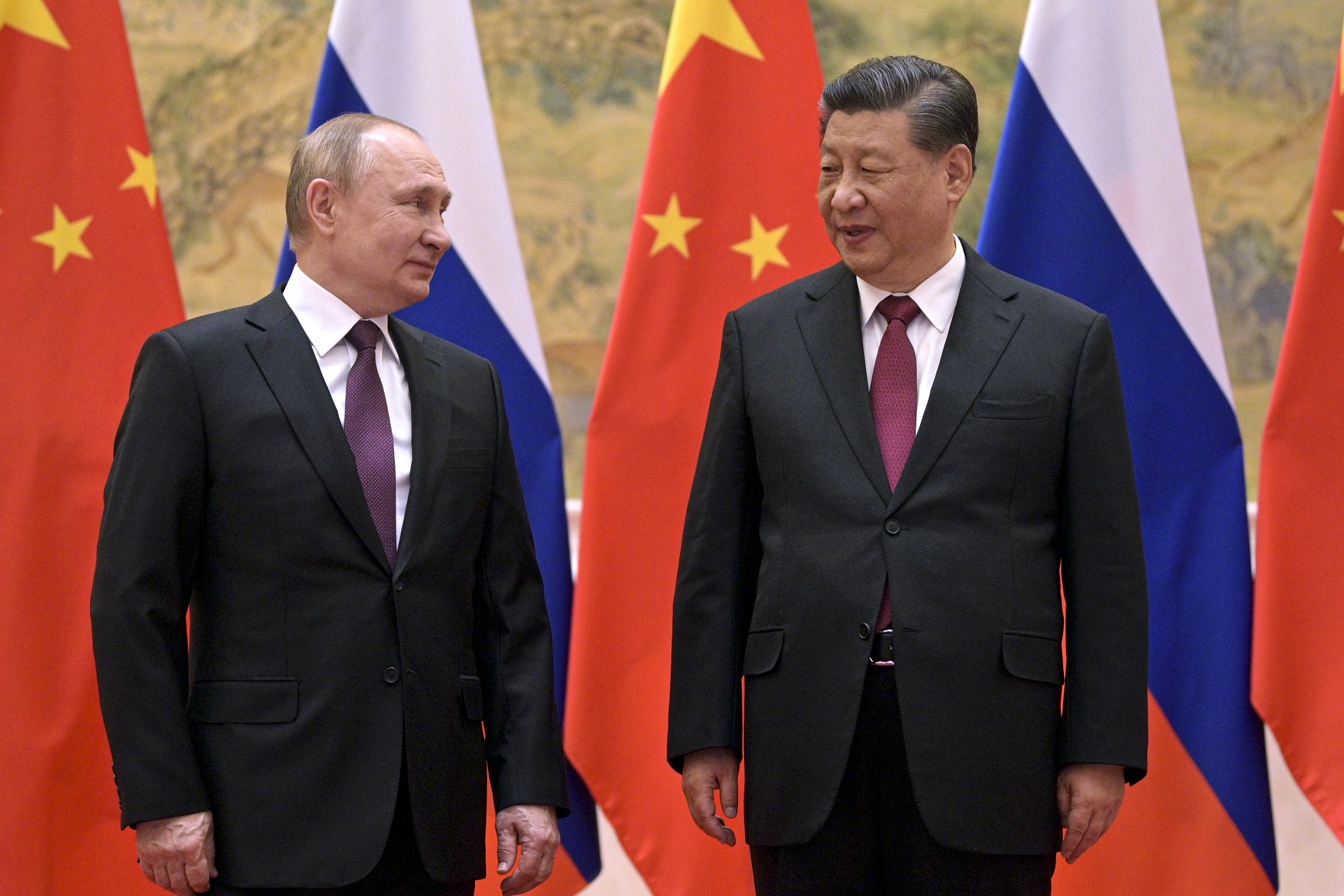 Chinese President Xi Jinping, right, and Russian President Vladimir Putin talk to each other during their meeting in Beijing, Feb. 4. China is the only friend that might help Russia blunt the impact of economic sanctions over its invasion of Ukraine. 