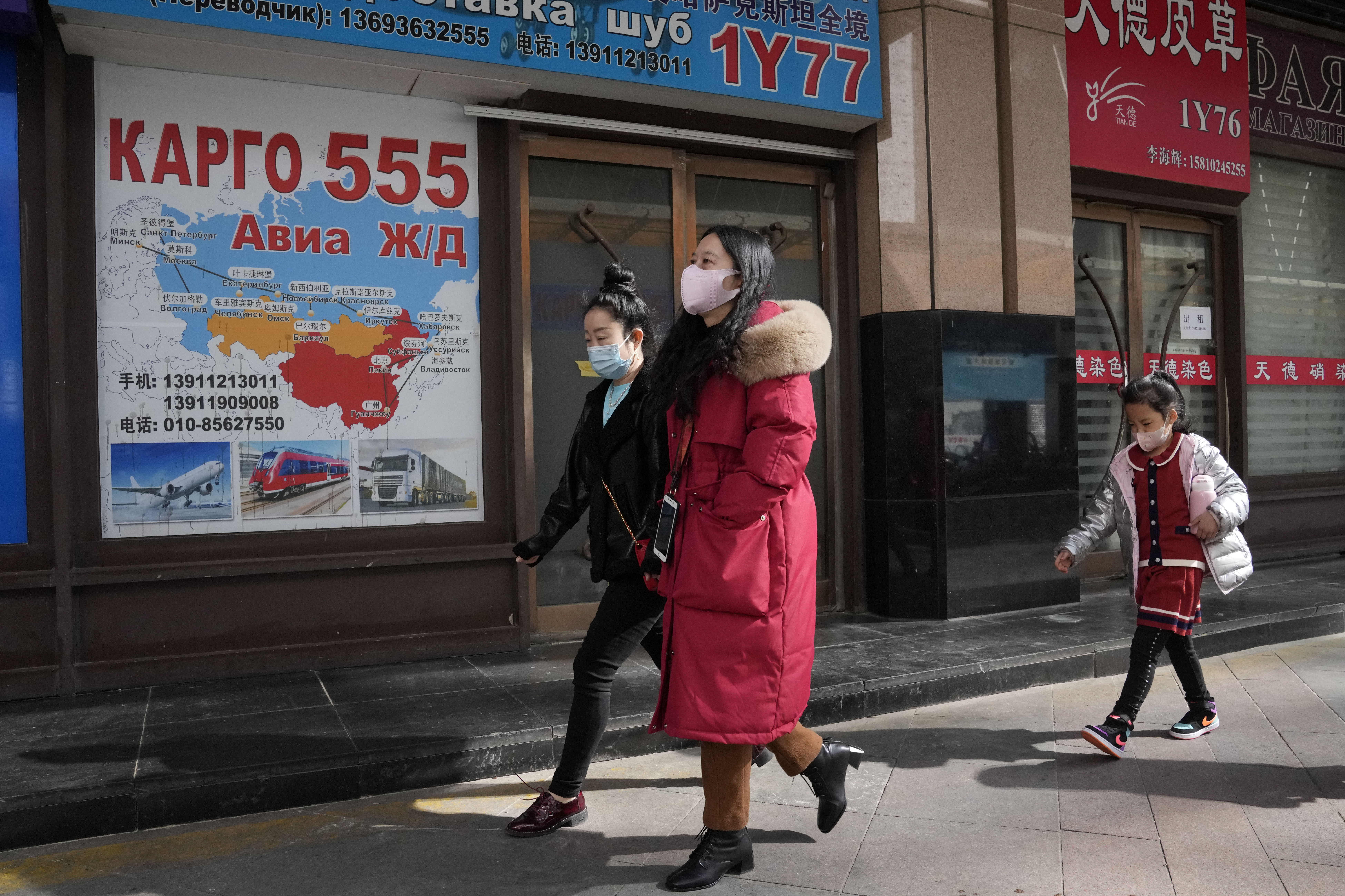 Residents past near shops at a mall, also known as Russia Market, for Russian traders on Saturday, Feb. 26, 2022, in Beijing. China is the only friend that might help Russia blunt the impact of economic sanctions over its invasion of Ukraine, but President Xi Jinping's government is giving no sign it might be willing to risk its own access to U.S. and European markets by doing too much.