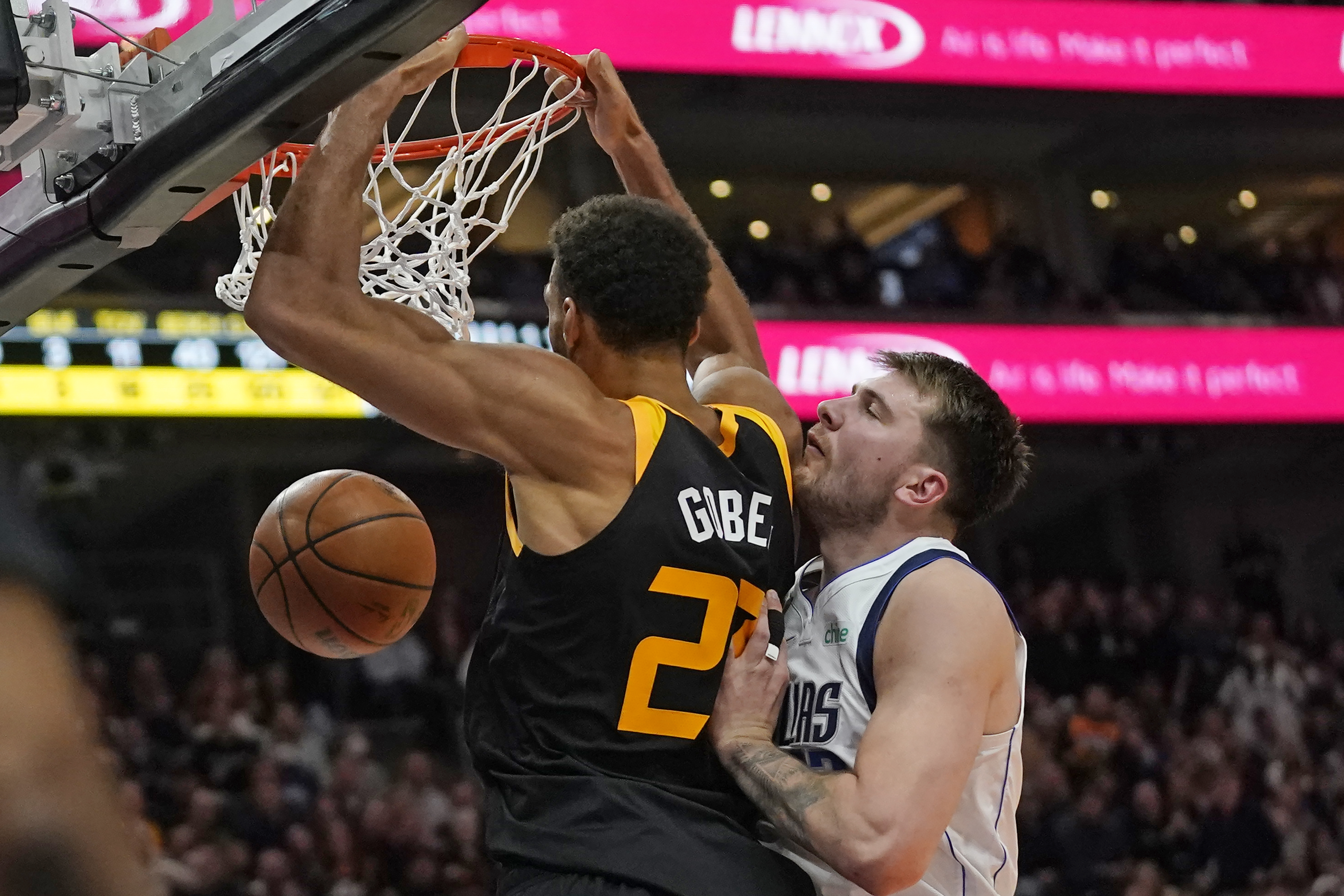 Utah Jazz center Rudy Gobert (27) dunks as Dallas Mavericks guard Luka Doncic defends during the second half of an NBA basketball game Friday, Feb. 25, 2022, in Salt Lake City. 