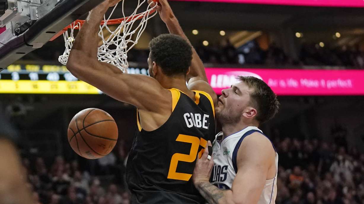 Utah Jazz center Rudy Gobert (27) dunks as Dallas Mavericks guard Luka Doncic defends during the second half of an NBA basketball game Friday, Feb. 25, 2022, in Salt Lake City.