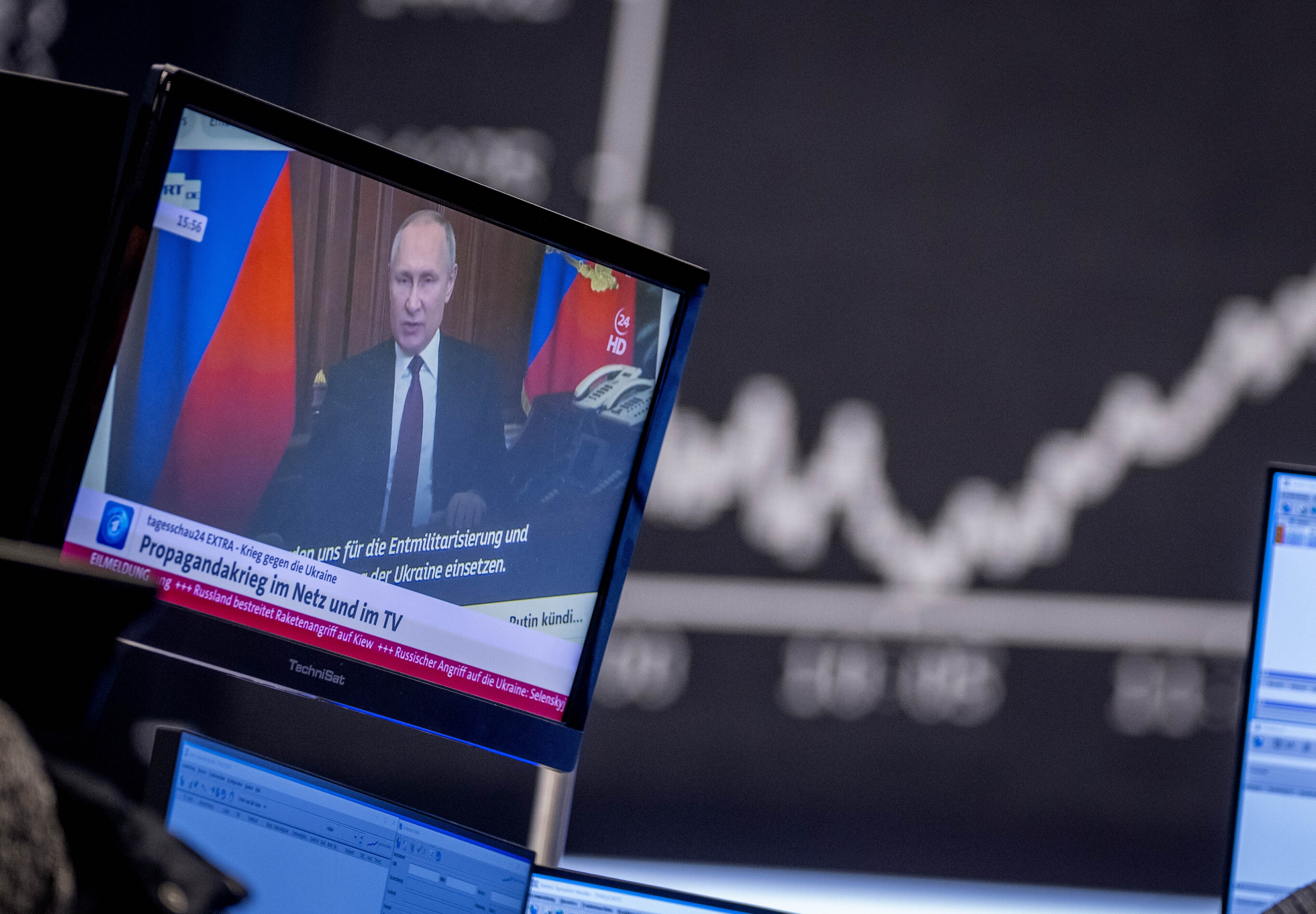 Russia President Vladimir Putin appears on a television screen at the stock market in Frankfurt, Germany, on Friday. Russia is revving up its sophisticated propaganda machine as its military advances in neighboring Ukraine.
