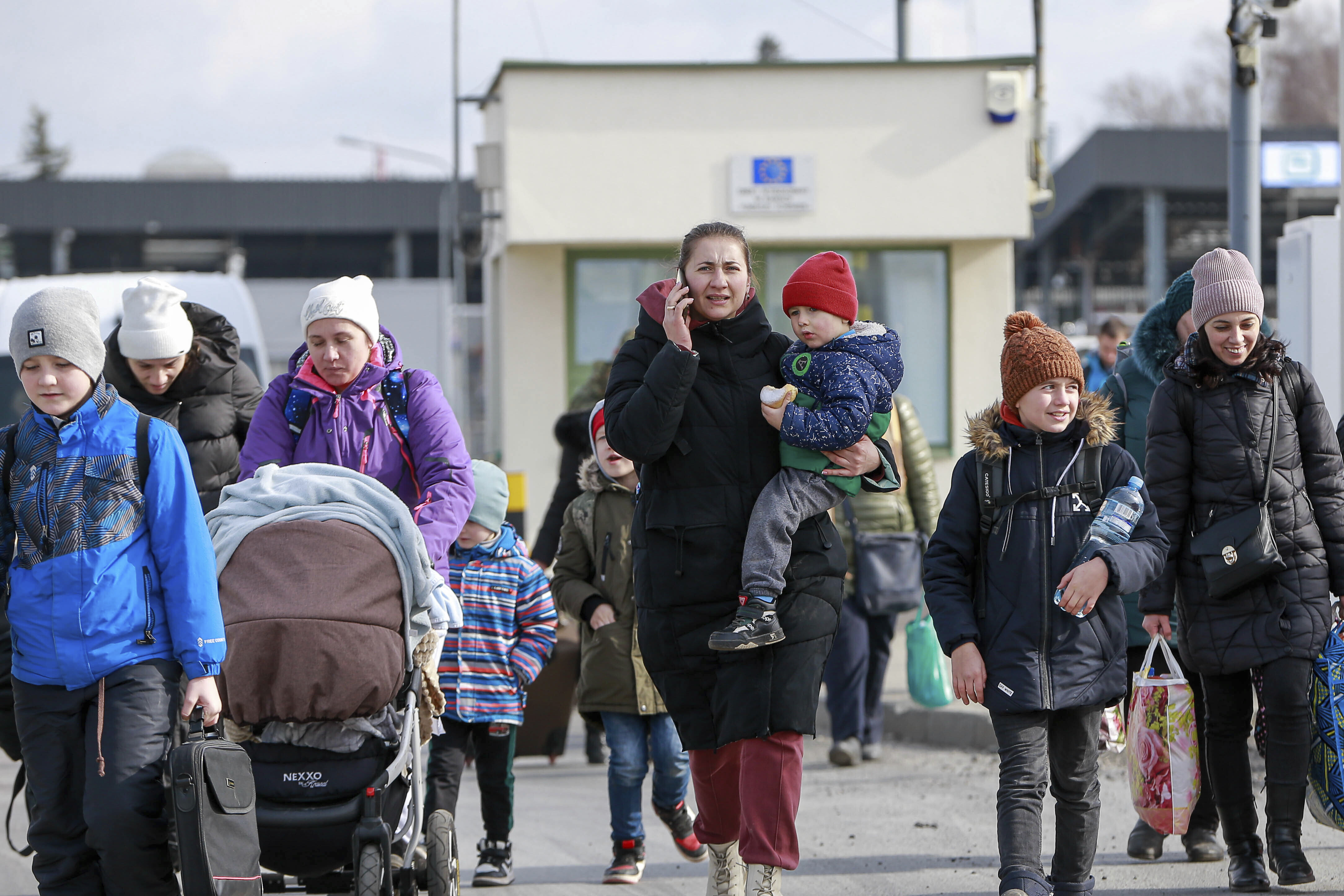 Refugees from Ukraine arrive at the Medyka border crossing in Poland, Saturday, Feb. 26, 2022. The U.N. refugee agency says nearly 120,000 people have so far fled Ukraine into neighboring countries in the wake of the Russian invasion.