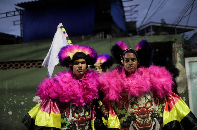 "Bate-bola" revellers perform during the traditional carnival festivity in a suburb in Rio de Janeiro despite Carnival celebrations being postponed to April due to the COVID-19 outbreak, in Rio de Janeiro, Brazil, Friday.