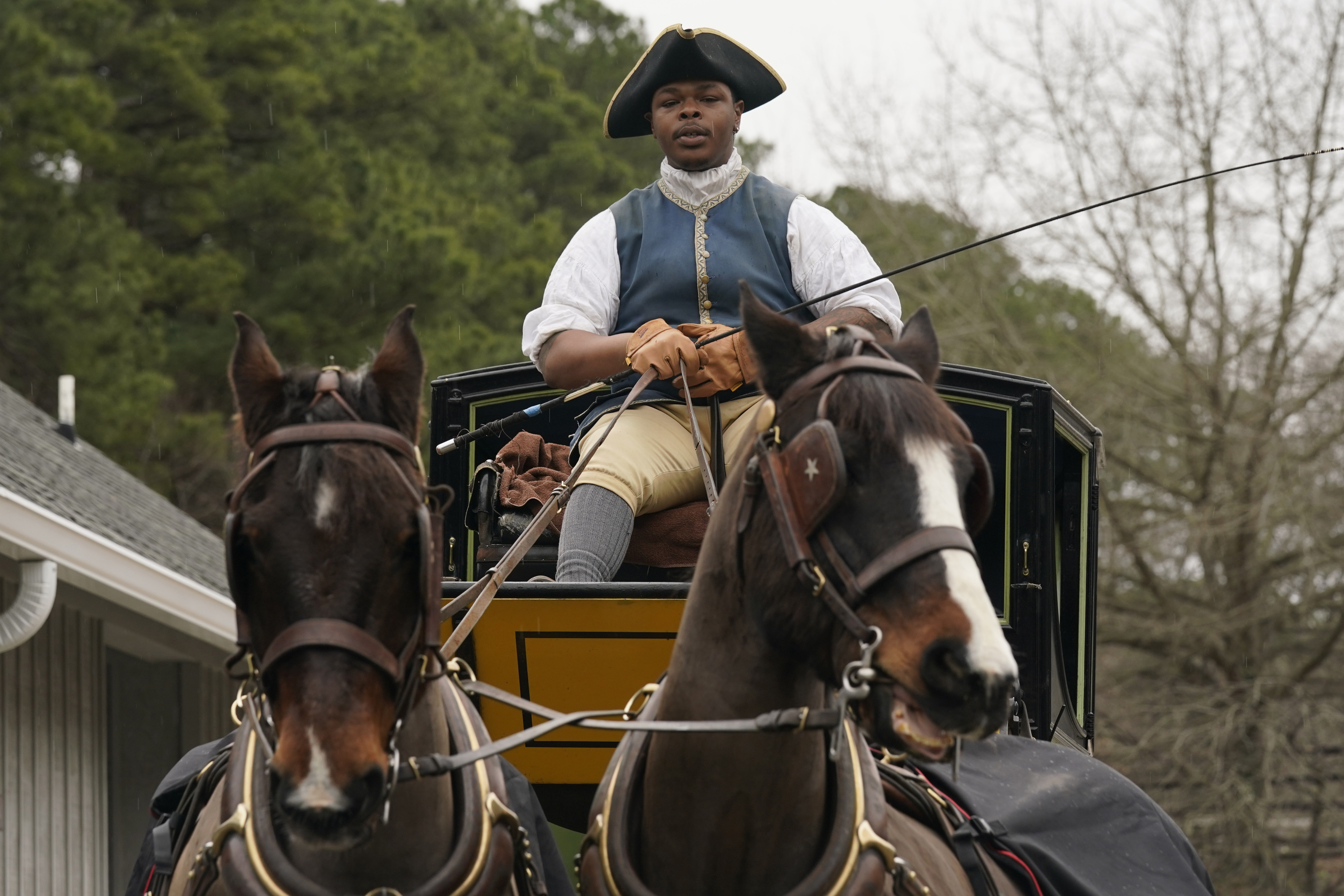 Colonial Williamsburg coachman Collin Ashe directs his horses as he drives his coach Thursday in Williamsburg, Va. Colonial Williamsburg has begun to honor the coachmen by naming a new carriage after one of them. 
