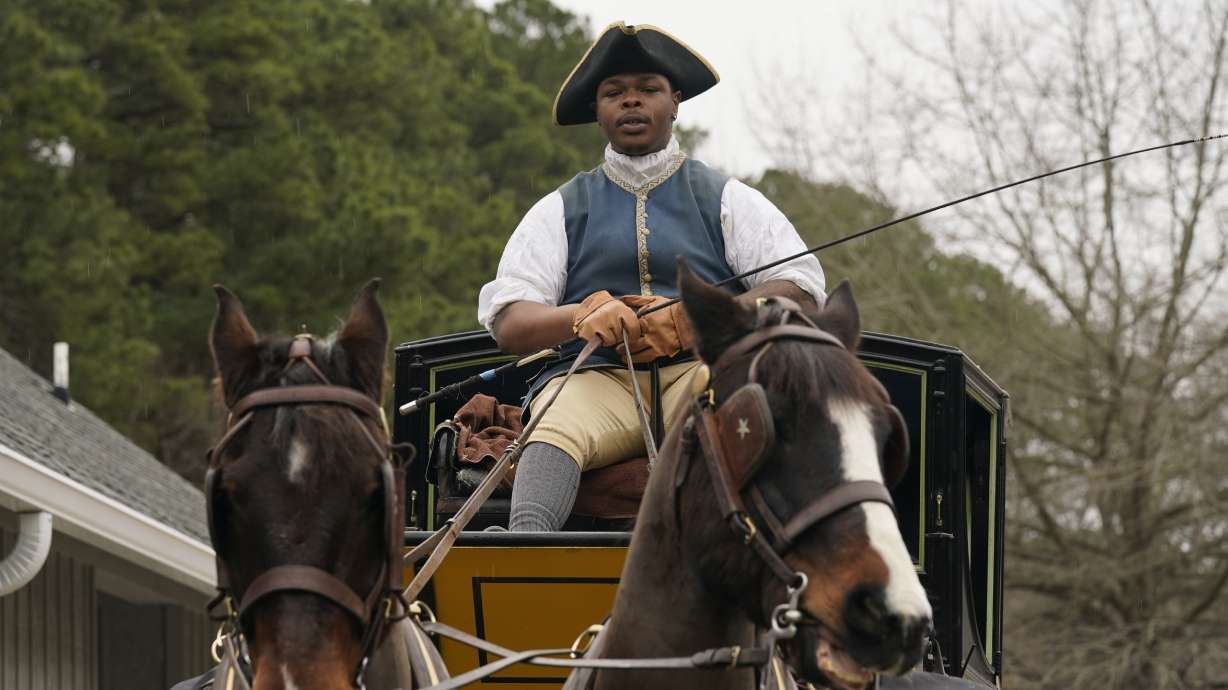 Colonial Williamsburg coachman Collin Ashe directs his horses as he drives his coach Thursday in Williamsburg, Va. Colonial Williamsburg has begun to honor the coachmen by naming a new carriage after one of them.
