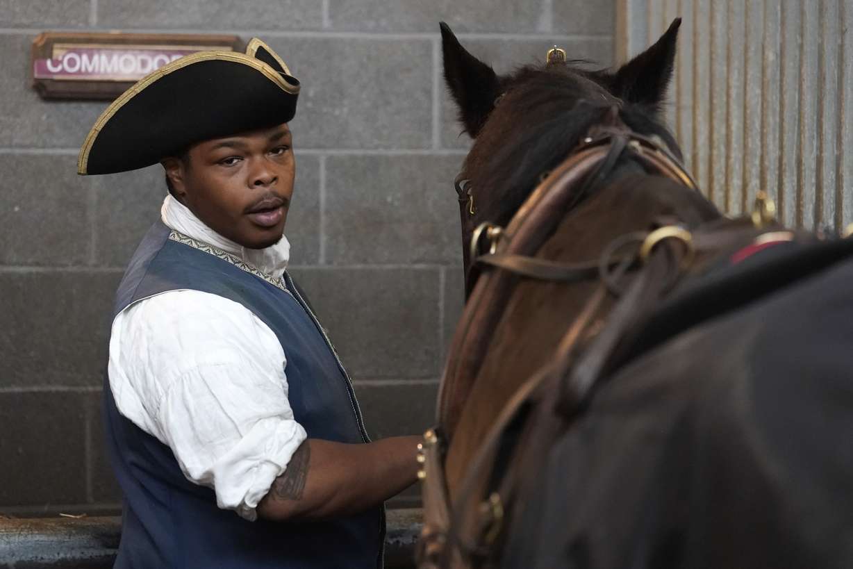 Colonial Williamsburg coachman Collin Ashe prepares his horse, Commodore, to pull a coach Thursday Feb. 24, 2022, in Williamsburg, Va. Colonial Williamsburg has begun to honor the coachmen by naming a new carriage after one of them.