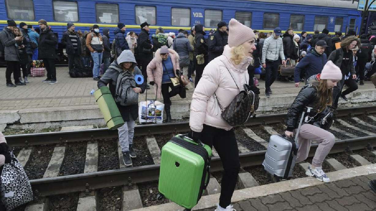 People gather to catch a train and leave Ukraine for neighboring countries at the railway station in Lviv, western Ukraine, Saturday. The U.N. refugee agency says nearly 120,000 people have so far fled Ukraine into neighboring countries in the wake of the Russian invasion.