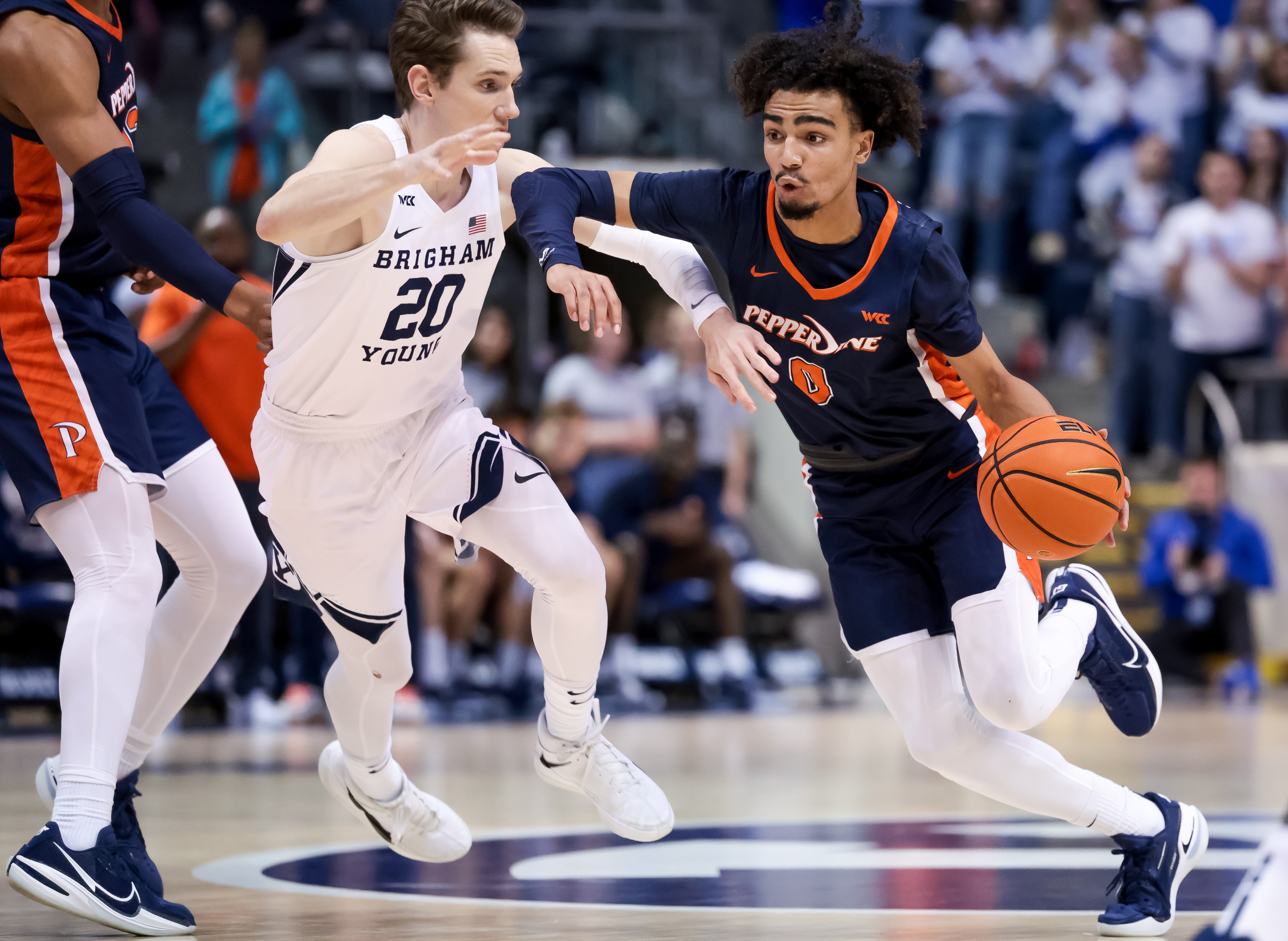 Pepperdine Waves guard Houston Mallette (0) drives against Brigham Young Cougars guard Spencer Johnson (20) during the game at the Marriott Center in Provo on Saturday, Feb. 26, 2022.