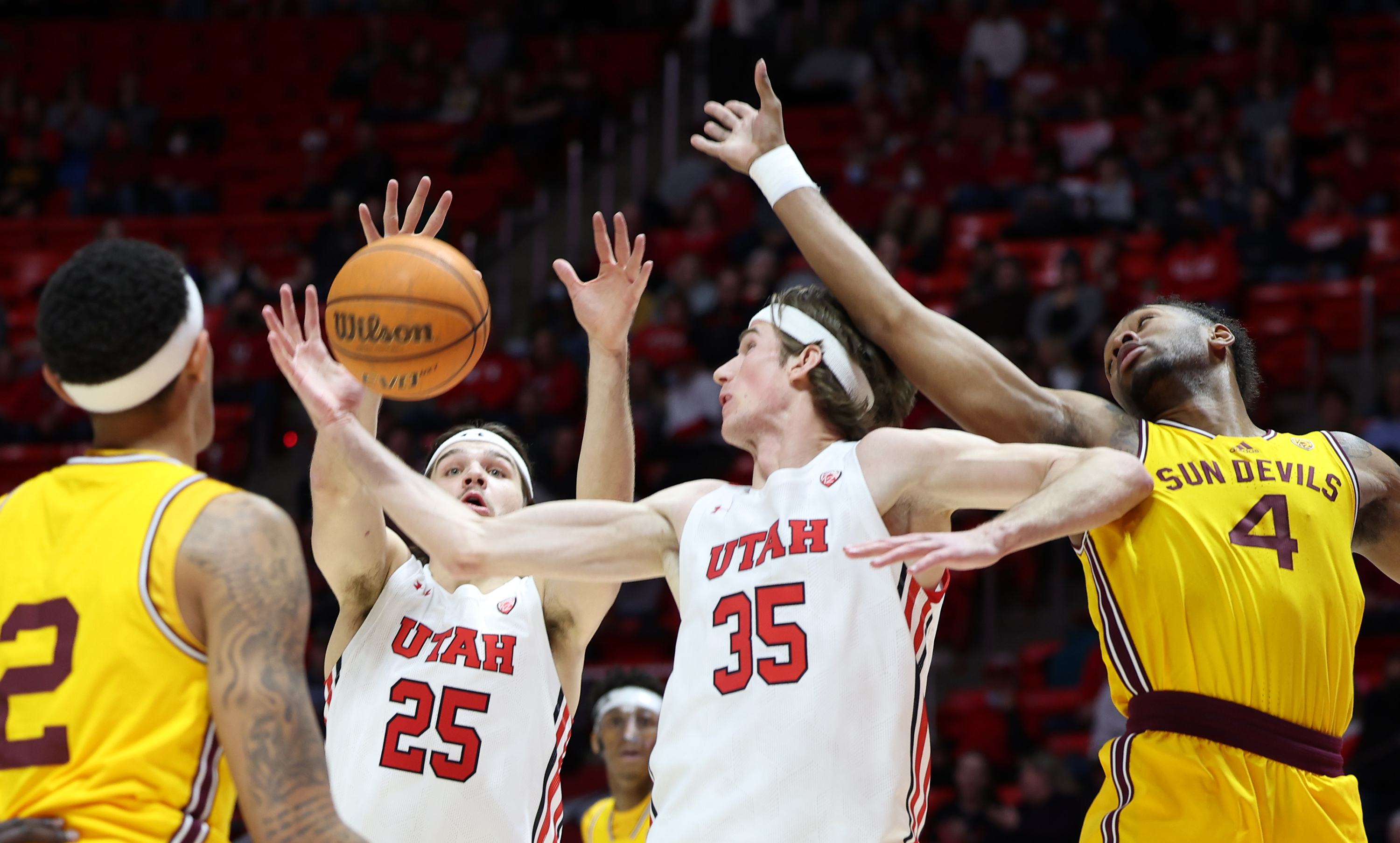 Utah Utes guard Rollie Worster (25) and Utah Utes center Branden Carlson (35) battle Arizona State Sun Devils forward Kimani Lawrence (4) for the rebound as Utah and Arizona State play an NCAA basketball game in the Huntsman Center at the University of Utah in Salt Lake City on Saturday, Feb. 26, 2022.