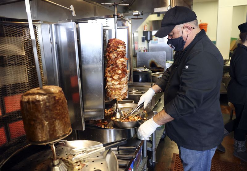 Azer Imranov, co-owner and operator of Sofia’s Doner
Kebab Express, carves chicken at the restaurant in West Jordan on
Thursday.
