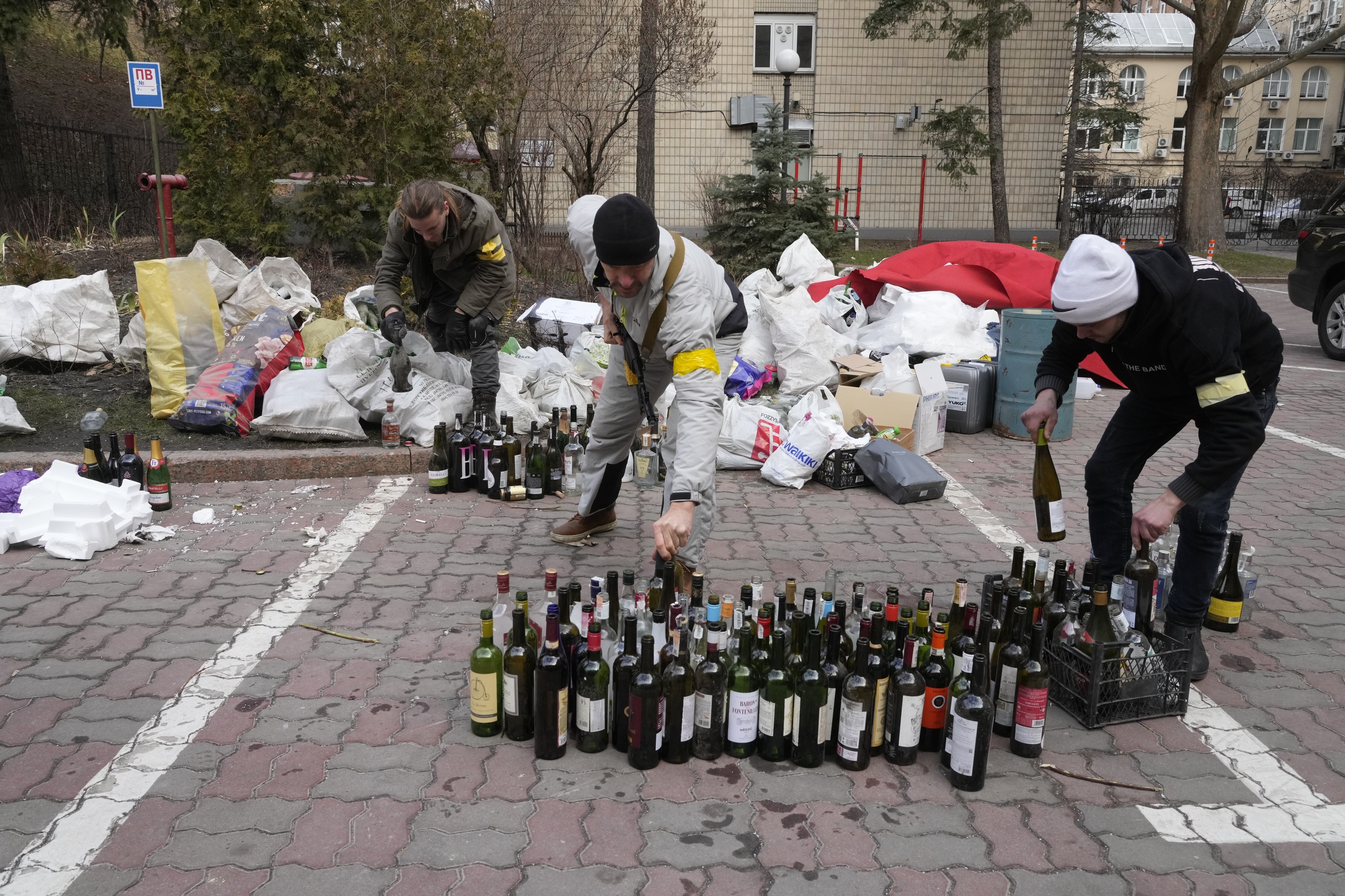 Members of civil defense prepare Molotov cocktails in a yard in Kyiv, Ukraine, Sunday. A Ukrainian official says street fighting has broken out in Ukraine's second-largest city of Kharkiv.