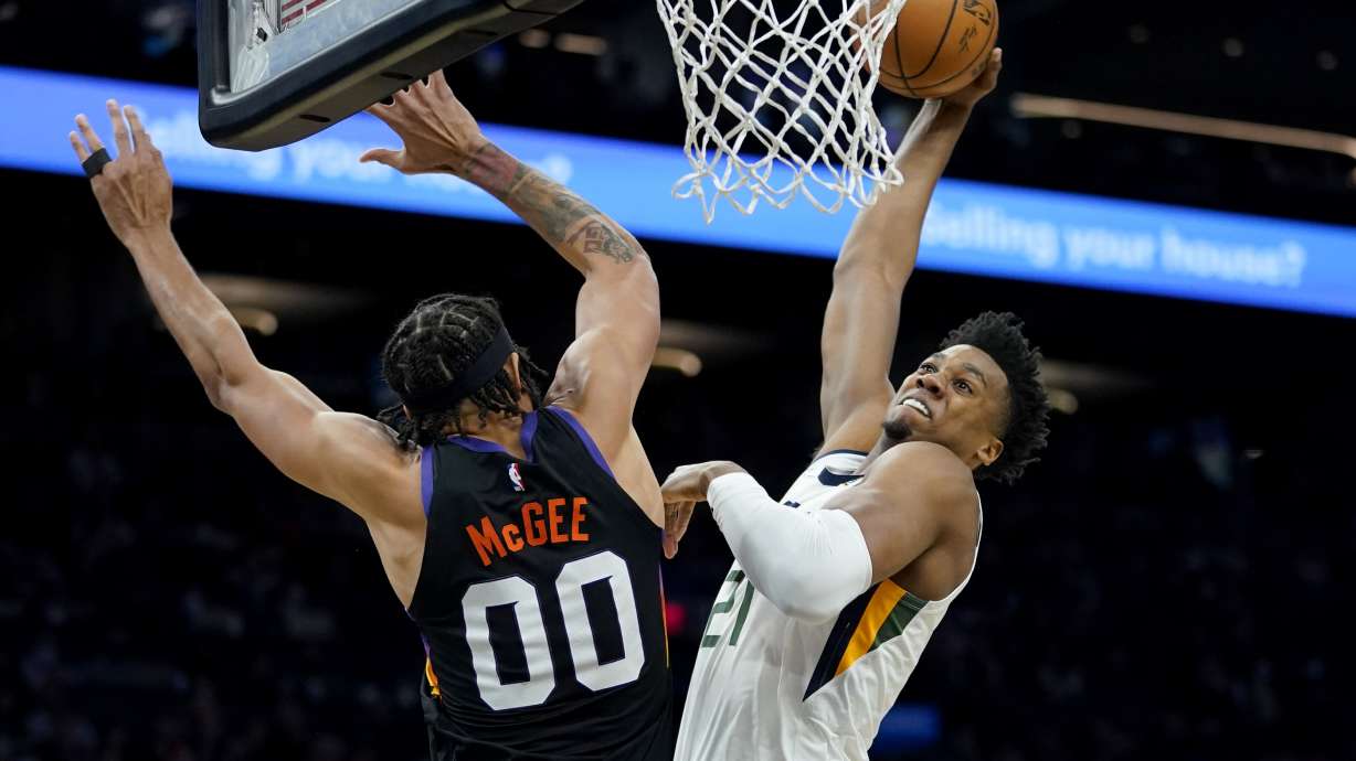 Utah Jazz center Hassan Whiteside (21) dunks over Phoenix Suns center JaVale McGee (00) during the first half of an NBA basketball game, Sunday, Feb. 27, 2022, in Phoenix.
