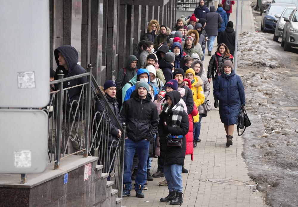 People stand in line to withdraw U.S. dollars and Euros from an ATM in St. Petersburg, Russia, Friday. Ordinary Russians faced the prospect of higher prices and crimped foreign travel as Western sanctions over the invasion of Ukraine sent the ruble plummeting, leading uneasy people to line up at banks and ATMs on Monday in a country that has seen more than one currency disaster in the post-Soviet era. 
