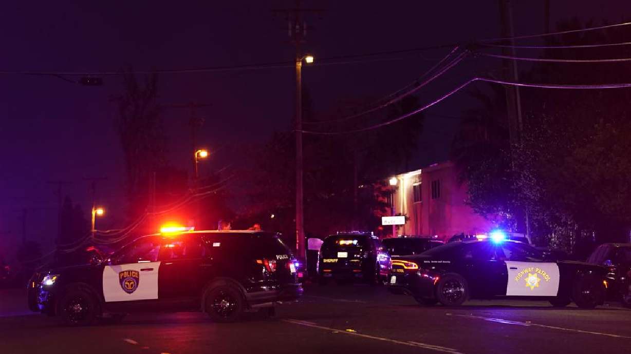 Law enforcement vehicles from several agencies block a street near the scene of a shooting in Sacramento, Calif., Monday. A man shot and killed his three children, their chaperone and himself during a supervised visit with the kids Monday at a church in Sacramento, California, authorities said.