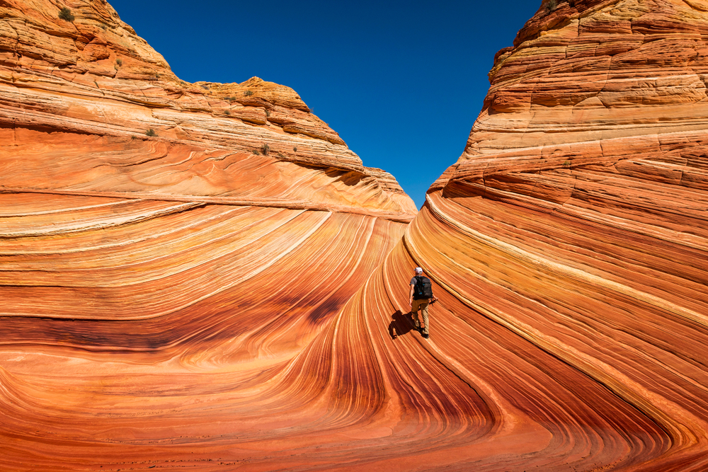 A person hikes the Wave in northern Arizona. The Bureau of Land Management announced on Tuesday changes to daily lotteries to hike the natural feature along the Utah-Arizona border.
