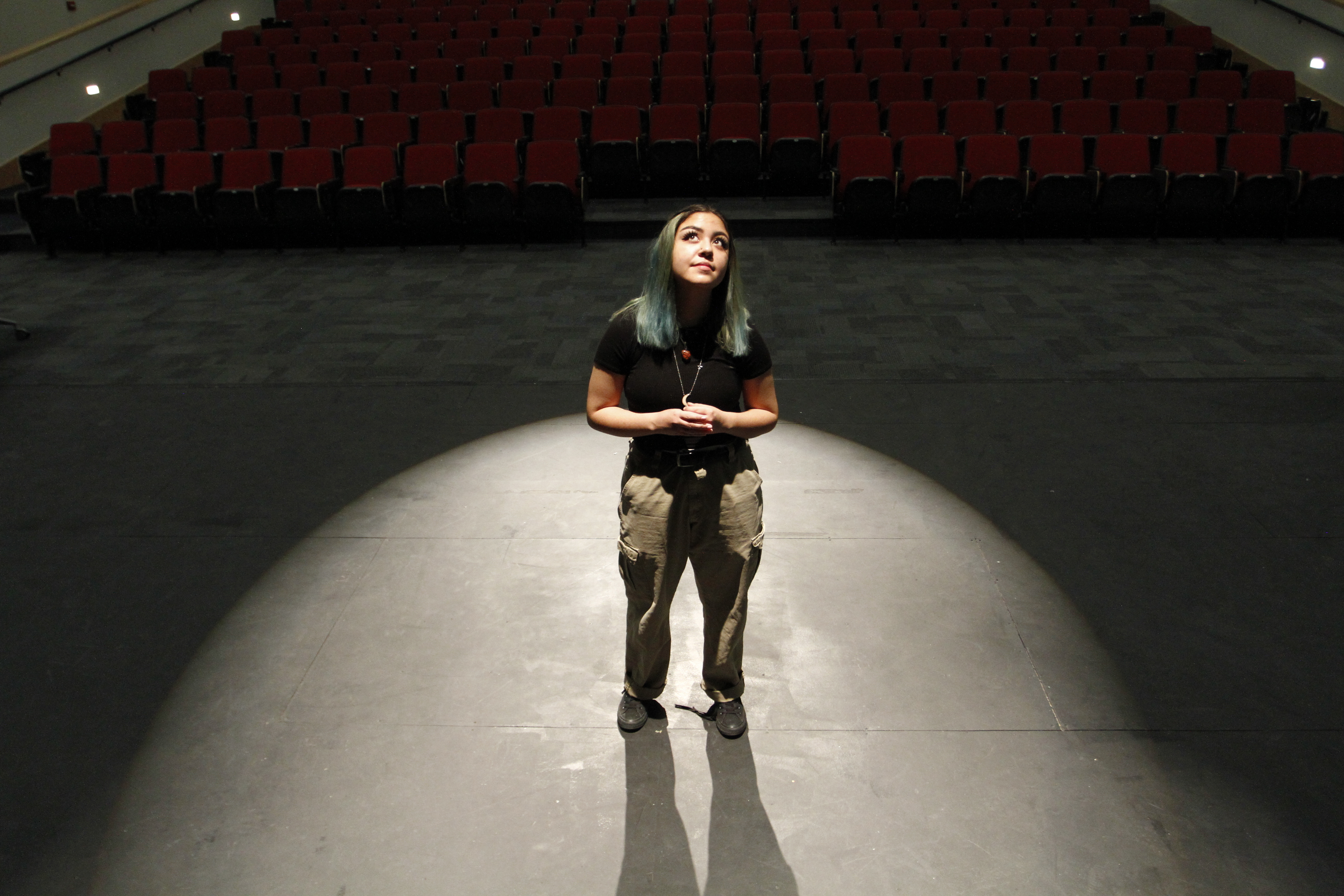 High school senior Helene Trujillo poses for a photo in the theater at Las Cruces High School, Feb. 10 in Las Cruces, N.M. Trujillo said having at least one of her teachers be flexible with deadlines and revisiting lessons has helped her feel less "suffocated." A growing number of schools now are becoming more deliberate about eliminating bias from grading systems.