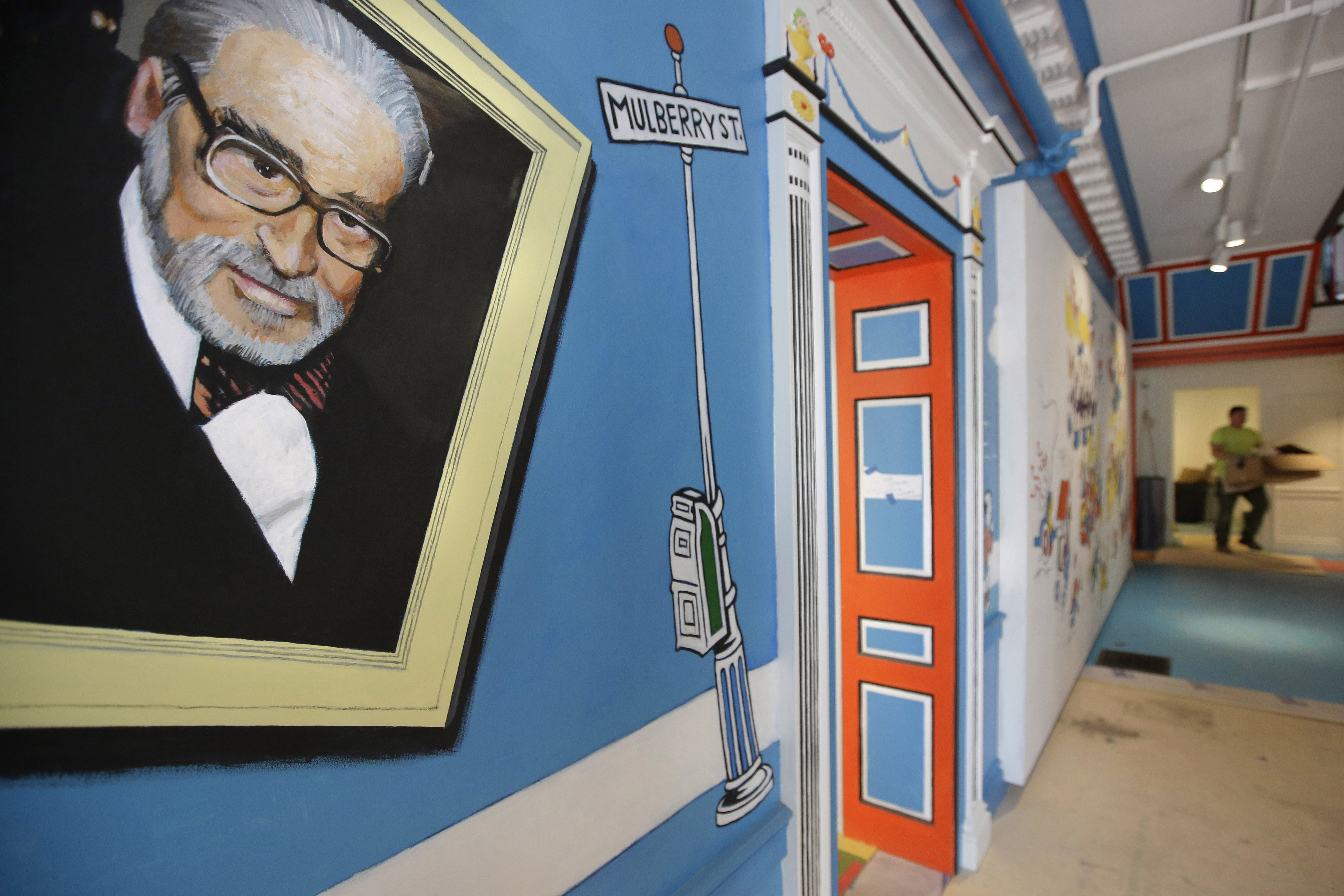 A mural that features Theodor Seuss Geisel, left, also known by his pen name Dr. Seuss, covers part of a wall near an entrance at The Amazing World of Dr. Seuss Museum, May 4, 2017, in Springfield, Mass. Sketches of fantastic creatures by Dr. Seuss that have never before been published will see the light of day in new books being written and illustrated by an inclusive group of up-and-coming authors and artists, the company that owns the intellectual property rights to Dr. Seuss' works announced Wednesday.
