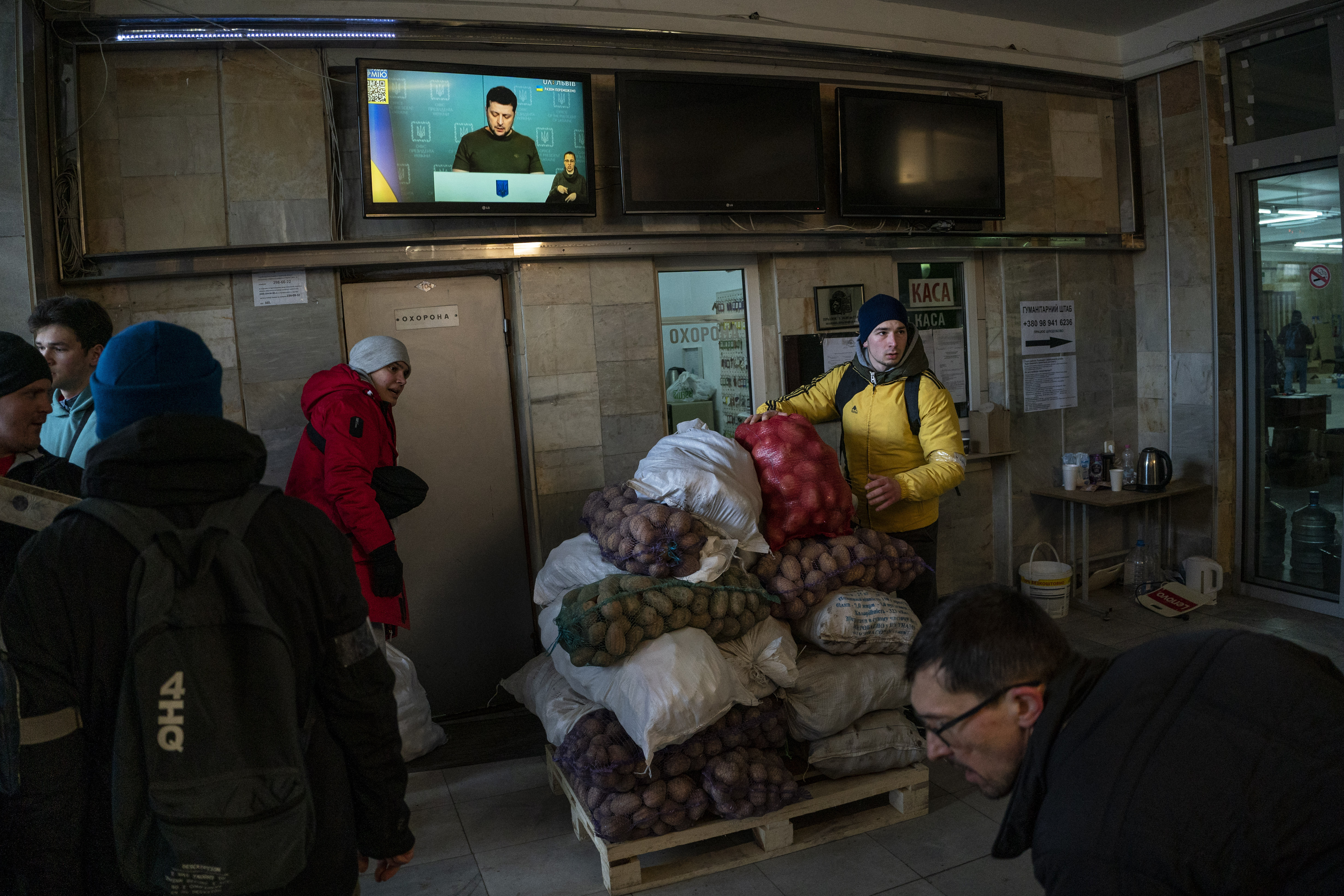 Ukrainian volunteers sort donated foods for later distribution to the local population while Ukrainian President Volodymyr Zelenskyy appears on television in Lviv, western Ukraine, Wednesday.