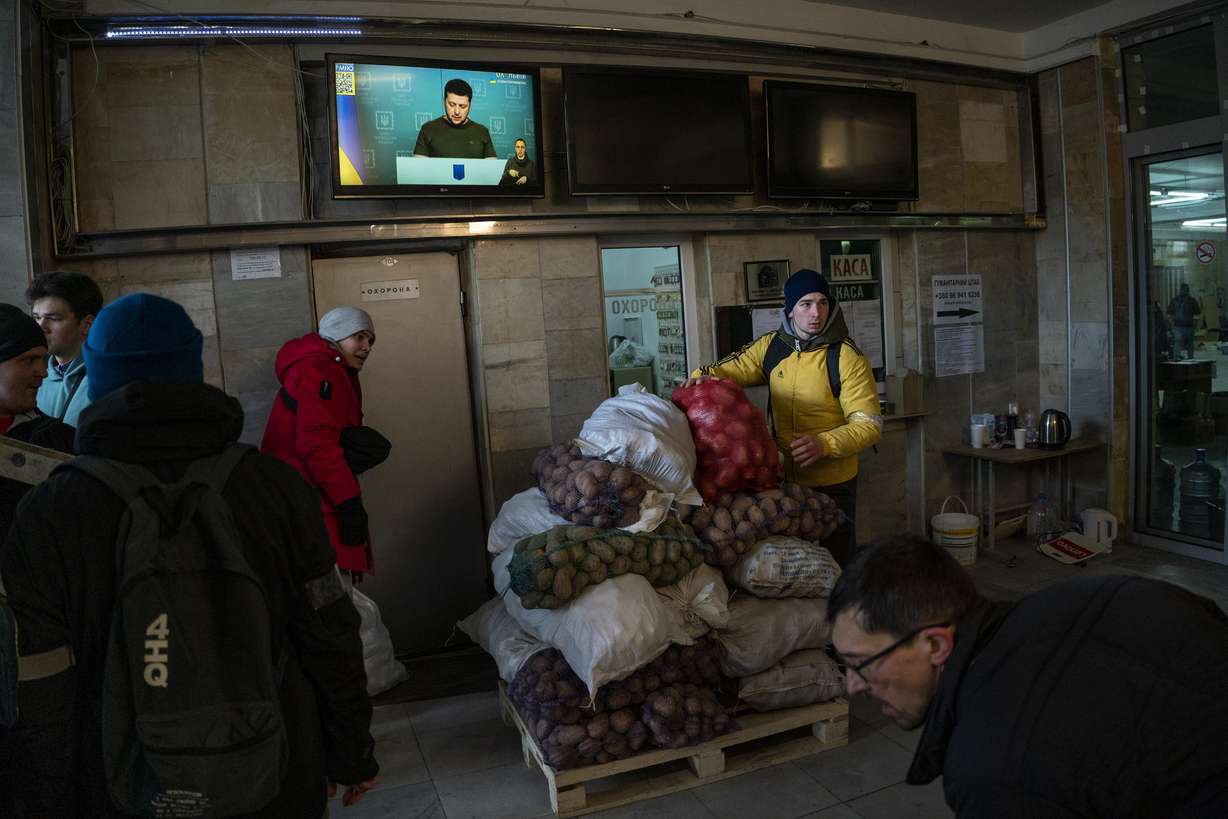 Ukrainian volunteers are sorting out donated food for later distribution to the local population, while Ukrainian President Vladimir Zelensky appears on television in Lviv, western Ukraine, on Wednesday.