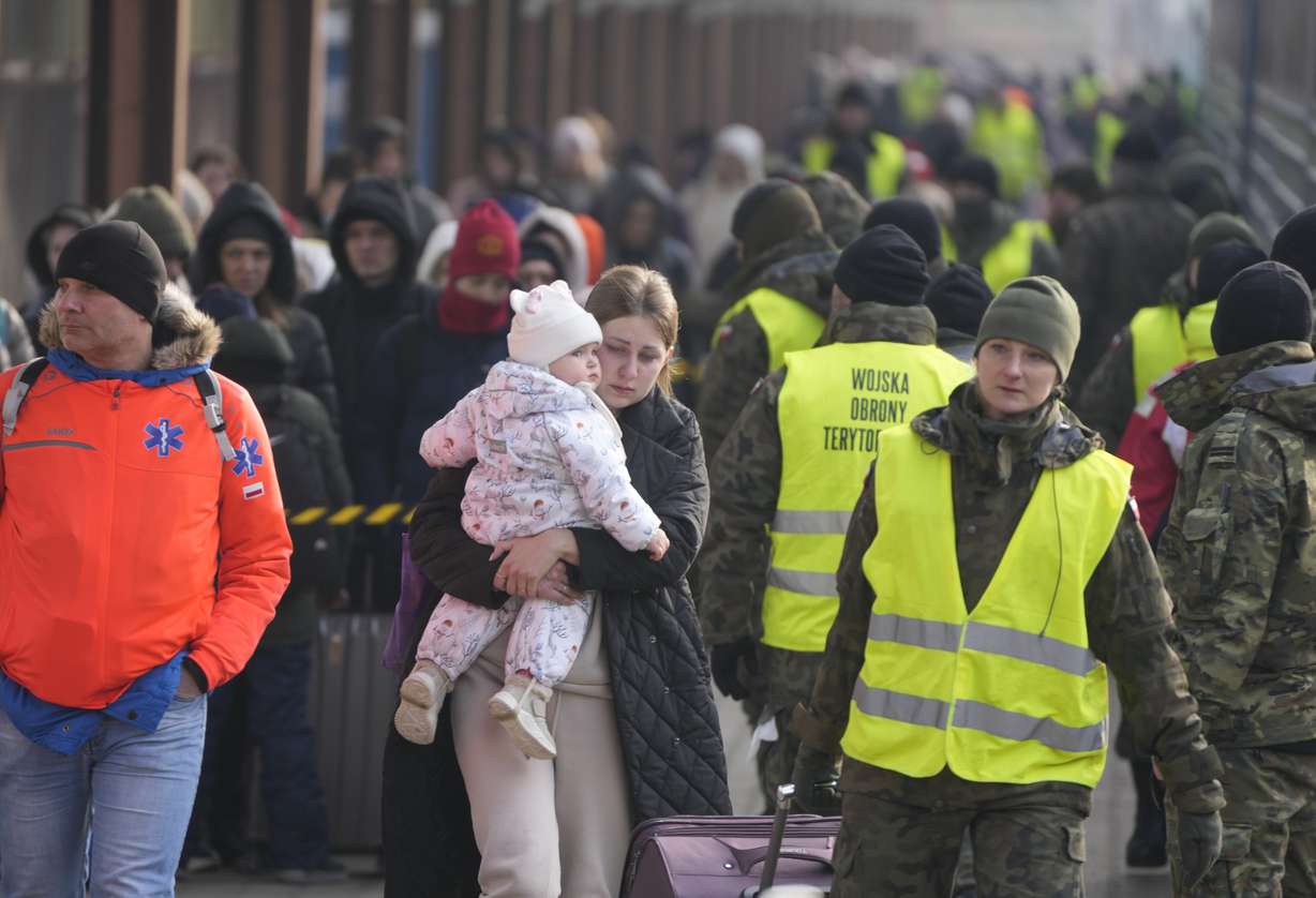 A woman holds a child as she arrives with other displaced Ukrainians at the station in Przemysl, Poland, Thursday.