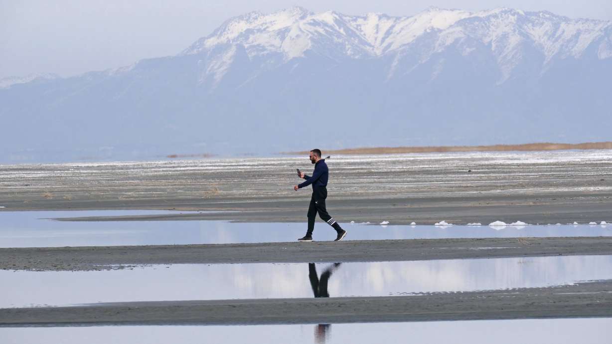 Ruben Gyoeltsyan walks across a sand bar at the receding edge of the Great Salt Lake, March 3, near Salt Lake City. Utah's Speaker of the House Brad Wilson, R-Kaysville, says he's bringing back the Great Salt Lake Summit in October.