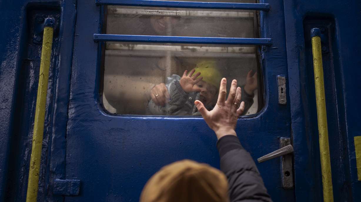 Stanislav, 40, says goodbye to his son David, 2, and his wife Anna, 35, on a train to Lviv at the Kyiv station, Ukraine, Thursday. Stanislav is staying to fight while his family is leaving the country to seek refuge in a neighboring country.