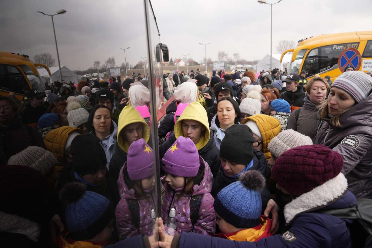 People fleeing from Ukraine queue to board on a bus at the border crossing in Medyka, Poland, Friday.