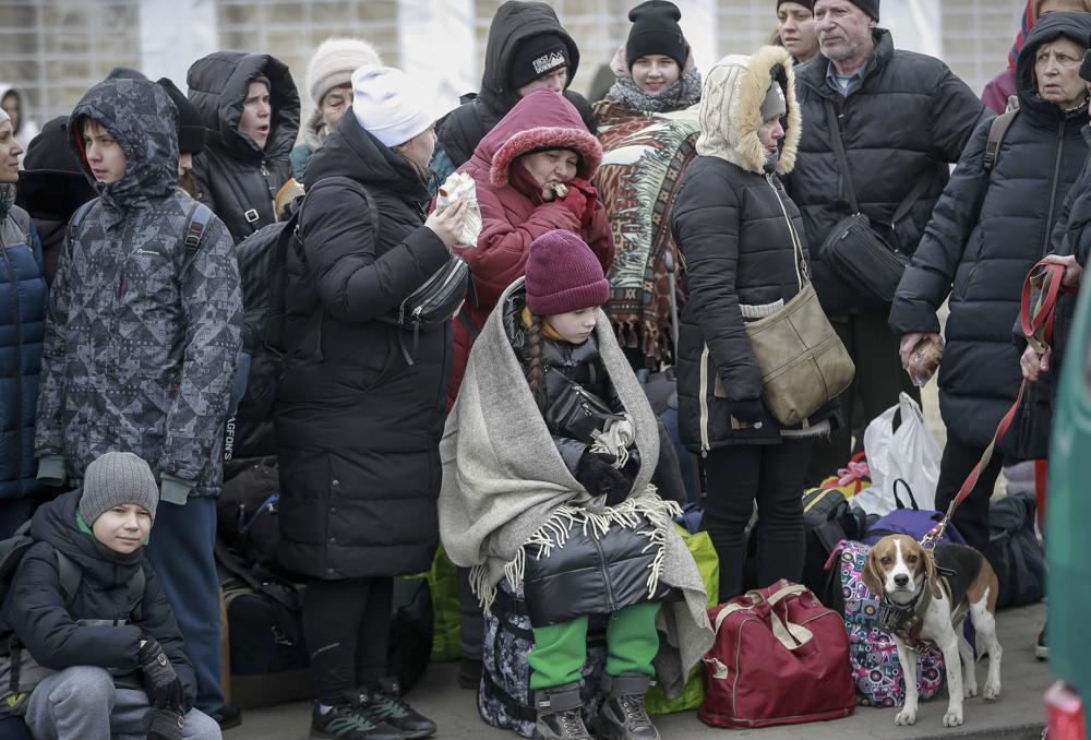 People who left Ukraine, wait for a bus to take them to the train station in Przemysl, at the border crossing in Medyka, Poland, Friday. More than 1 million people have fled Ukraine following Russia's invasion in the swiftest refugee exodus in this century, the United Nations said Thursday. 