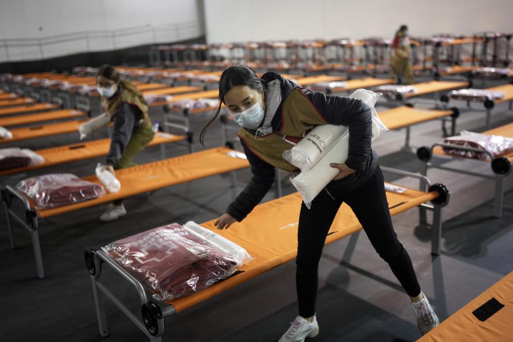 Members of the Portuguese Red Cross prepare cots at a sports hall converted to temporarily shelter Ukrainian refugees arriving in Lisbon, Thursday. The United Nations' refugee agency says 1 million people have fled Ukraine since Russia's invasion less than a week ago.