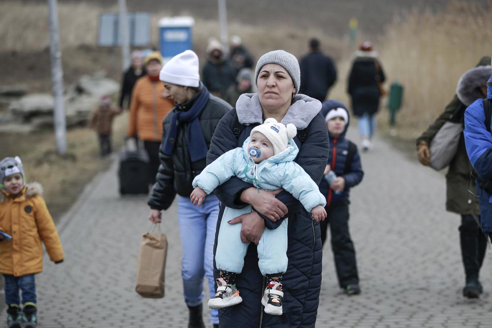 A woman holding a baby arrives from Ukraine, at the border crossing in Medyka, Poland, Friday. More than 1 million people have fled Ukraine following Russia's invasion in the swiftest refugee exodus in this century, the United Nations said Thursday.