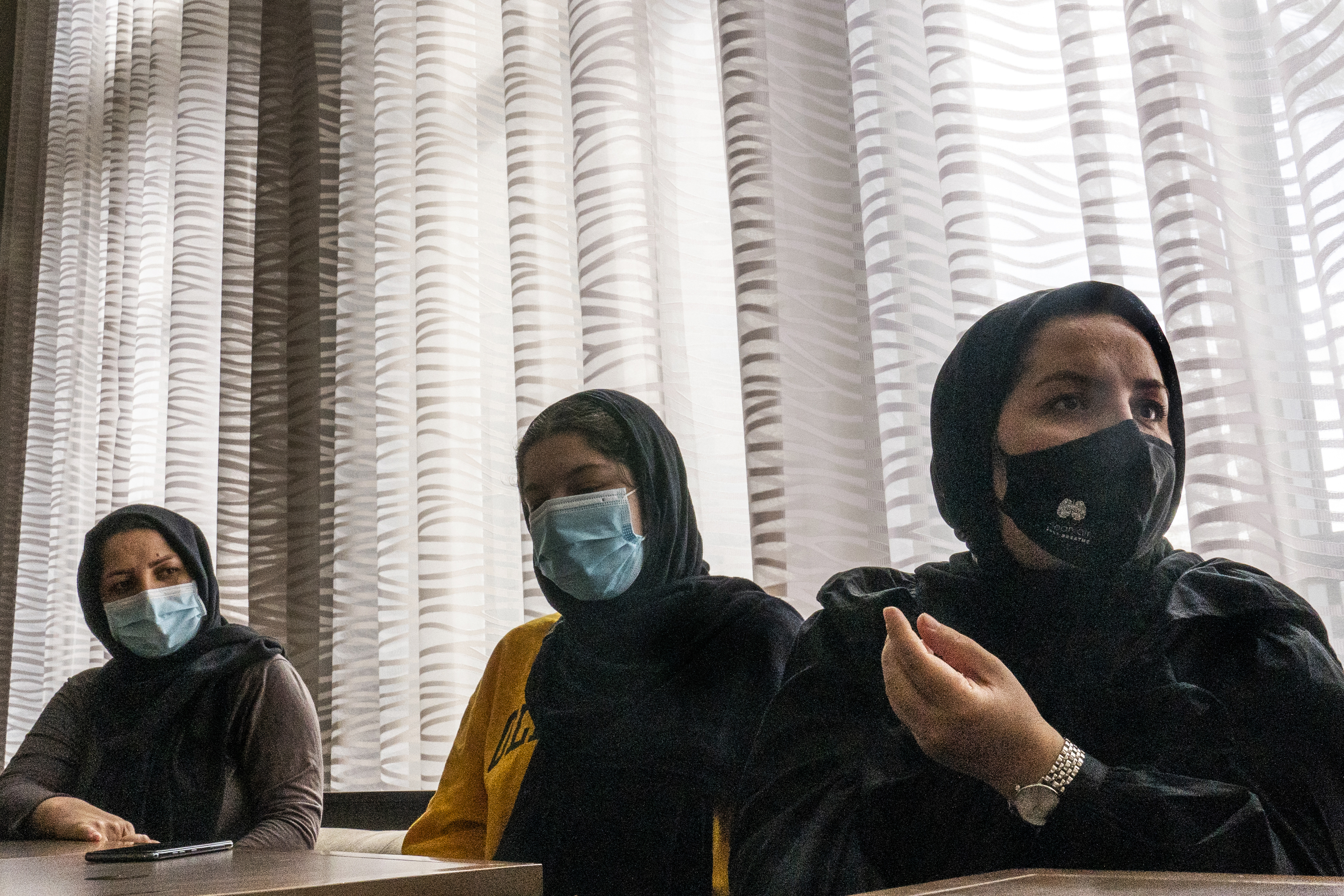 Afghan refugee Mozhgan Entazari, right, comments on the challenge of finding proper housing for her family in Southern California, during an interview at a hotel lobby in Irvine, Calif., Tuesday, Feb. 15, 2022. Without a job, credit history, or co-signer, Entazari said it was incredibly difficult to find housing, especially since landlords have become skittish after taking an economic hit during the coronavirus pandemic. And without an address, she said she and her husband couldn't get jobs and her kids couldn't enroll in school.