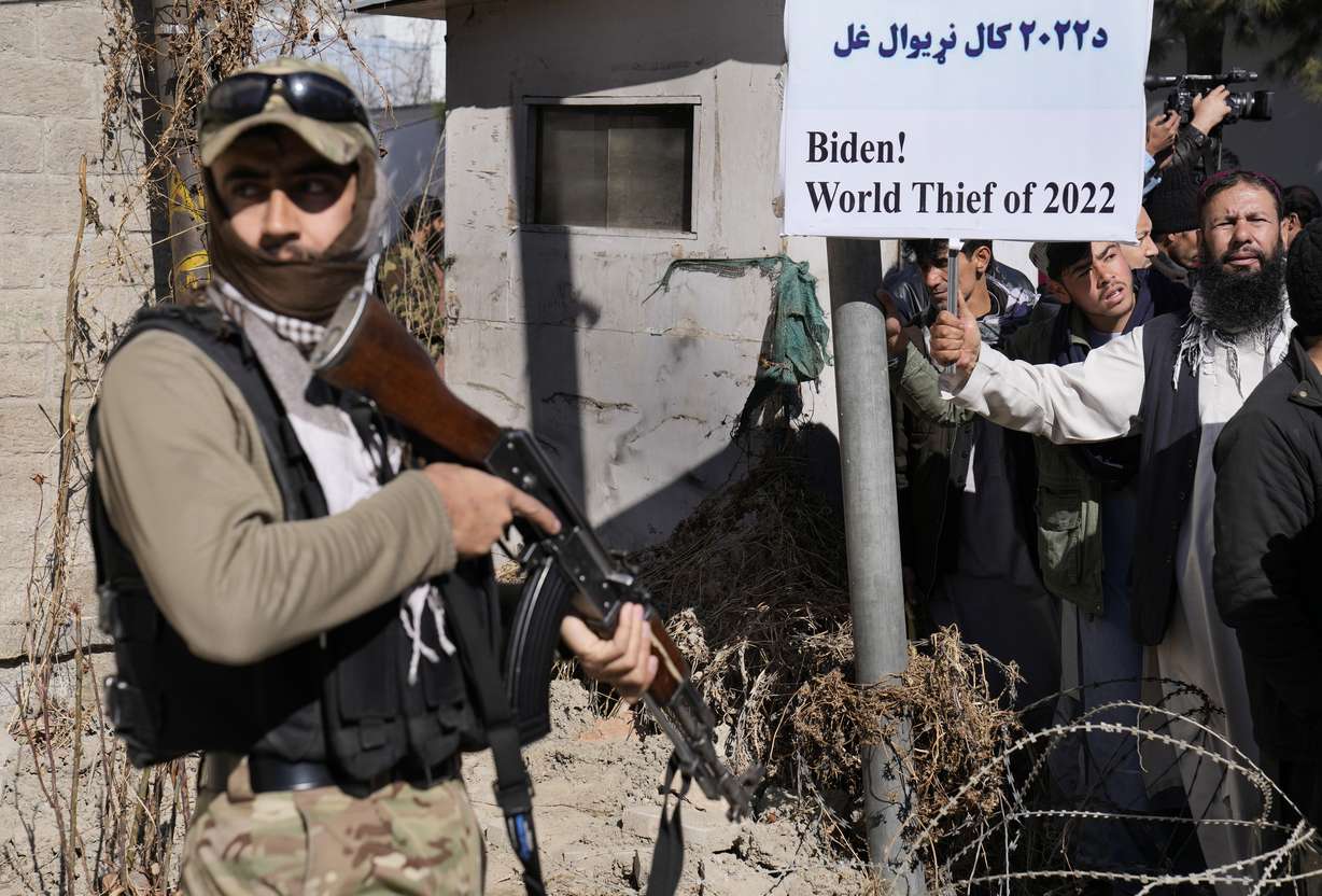 A Taliban fighter stands guard in front of protesters condemning President Joe Biden's decision on frozen Afghan assets in Kabul, Afghanistan, Feb. 15. After winding down 20 years of "endless" war in which the vast majority of Americans felt little impact on their daily lives, Biden now finds the U.S. mired in a conflict in Ukraine.