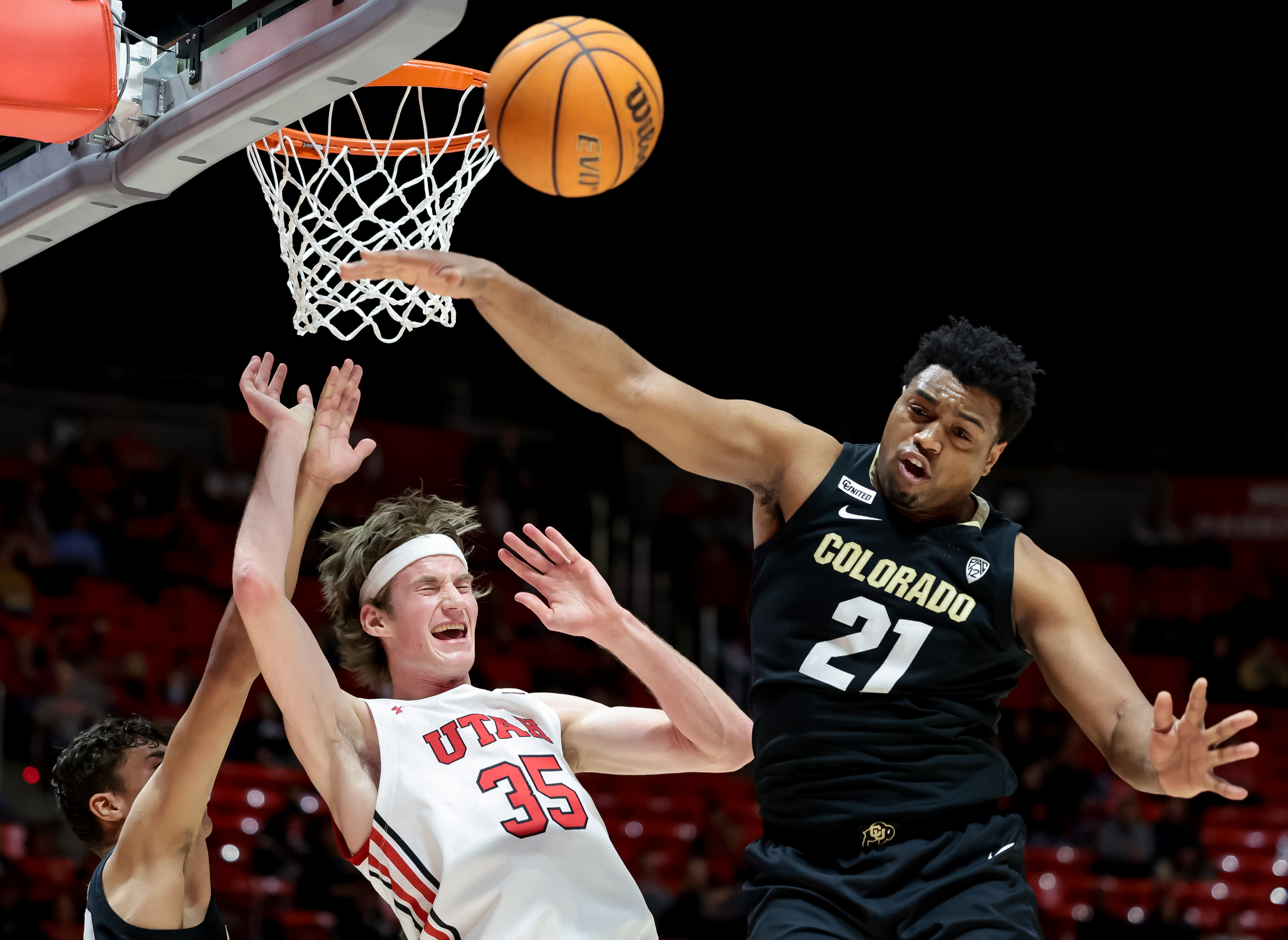 Colorado Buffaloes forward Tristan da Silva (23), left, is charged with a foul as Utah Utes center Branden Carlson (35) goes to the hoop between Silva and Colorado Buffaloes forward Evan Battey (21) during the game at the Huntsman Center in Salt Lake City on Saturday, March 5, 2022.