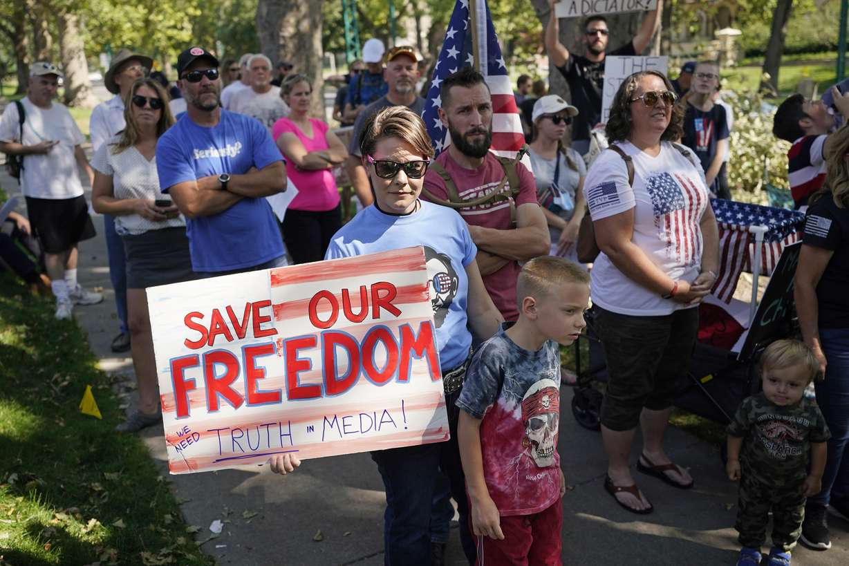 People protest Gov. Gary Herbert during an anti-mask rally outside of the Governor's Mansion, Sept. 12, 2020, in Salt Lake City. The official global death toll from COVID-19 is on the verge of eclipsing 6 million — underscoring that the pandemic, now in its third year, is far from over.