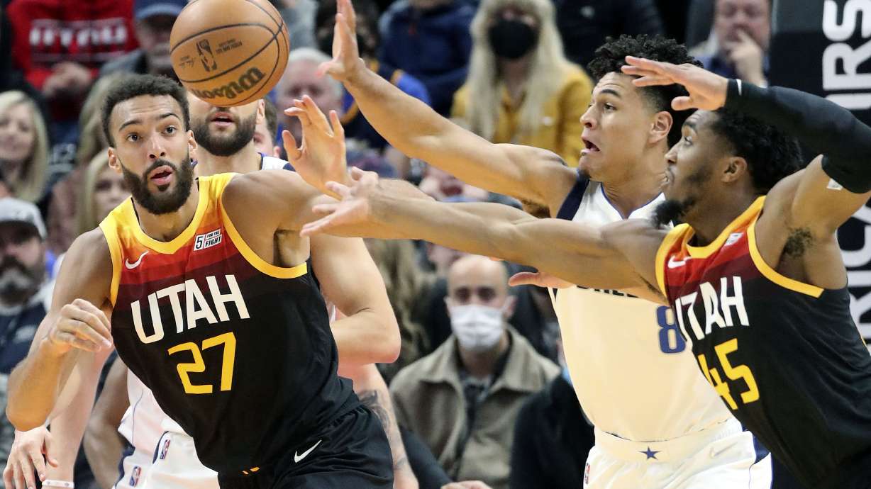 Utah Jazz center Rudy Gobert (27), Dallas Mavericks guard Josh Green (8) and Utah Jazz guard Donovan Mitchell (45) reach for the ball during an NBA game at the Vivint Arena in Salt Lake City on Friday, Feb. 25, 2022.