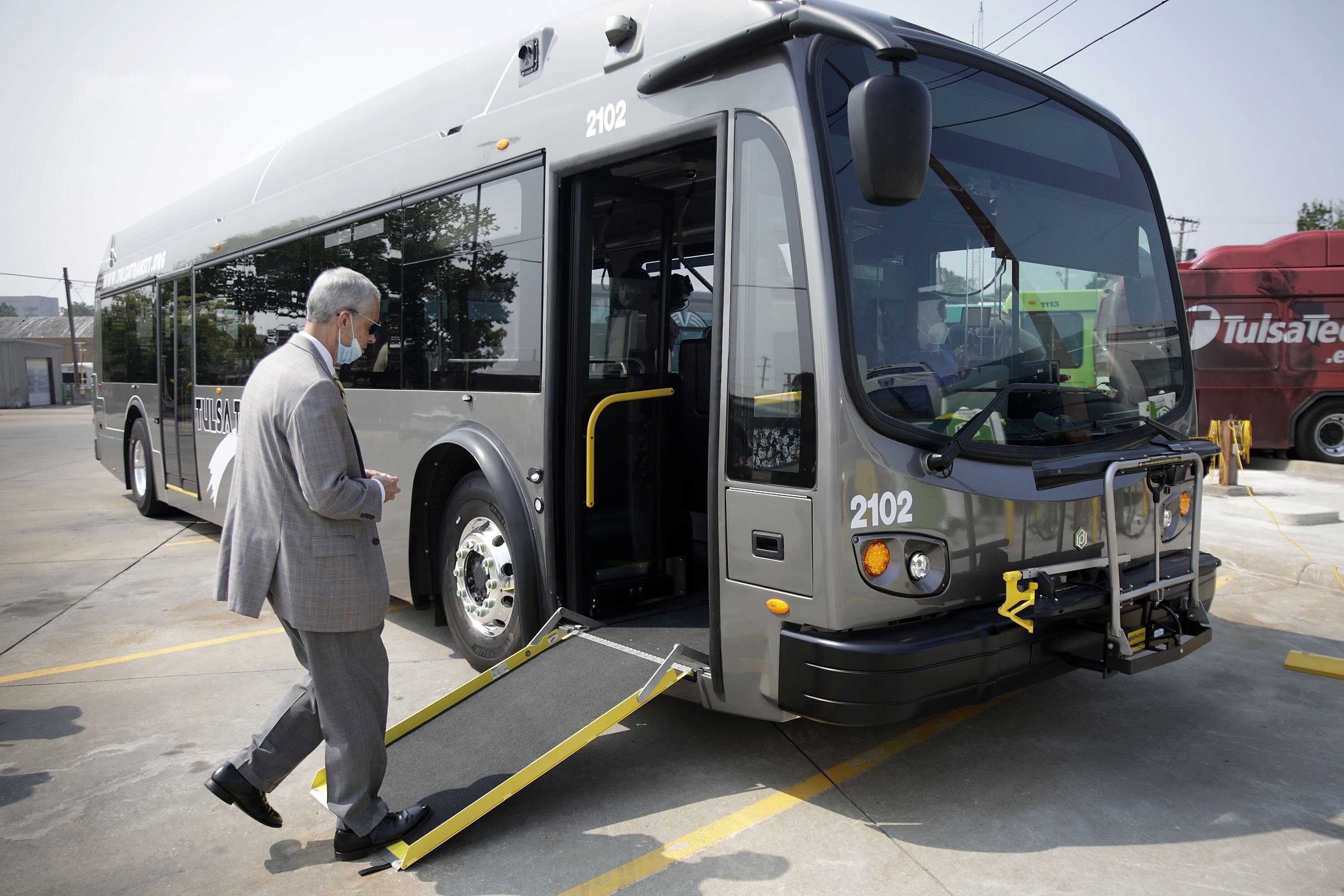 Tulsa Transit General Manager Ted Rieck boards a new electric bus on Aug. 3, 2021, in Tulsa, Okla. Public transit systems straining to win back riders after crushing waves of the COVID-19 pandemic are getting a $3 billion boost to stay afloat and invest in electric buses.