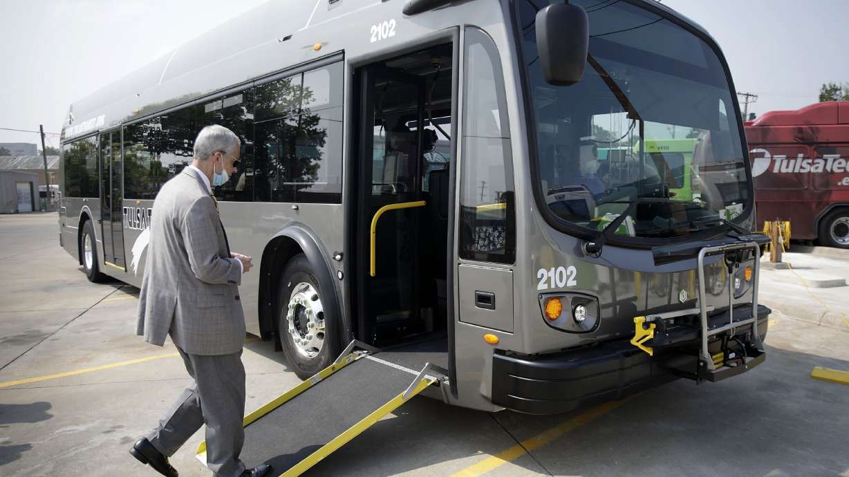 Tulsa Transit General Manager Ted Rieck boards a new electric bus on Aug. 3, 2021, in Tulsa, Okla. Public transit systems straining to win back riders after crushing waves of the COVID-19 pandemic are getting a $3 billion boost to stay afloat and invest in electric buses.
