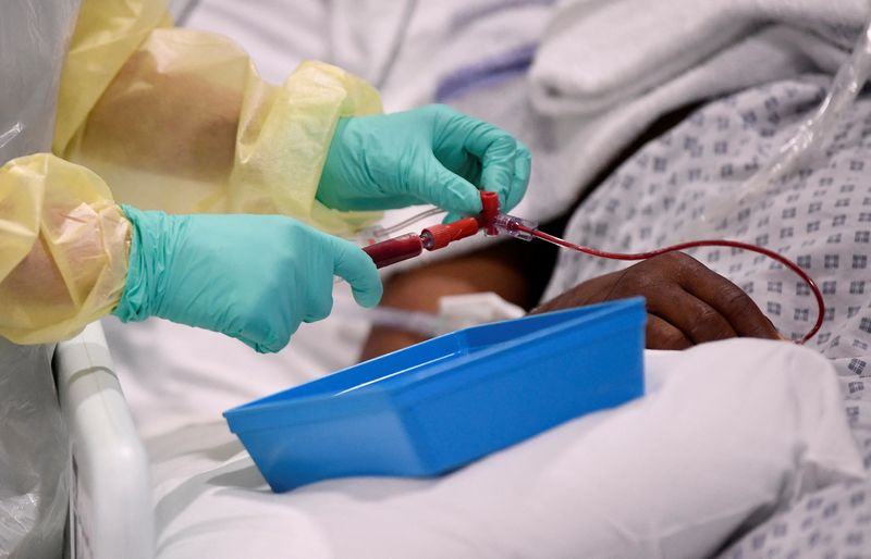 A nurse helps with treatment of a COVID-19 patient in the ICU at Milton Keynes University Hospital in Britain, amid the spread of the pandemic on Jan. 20, 2021.
