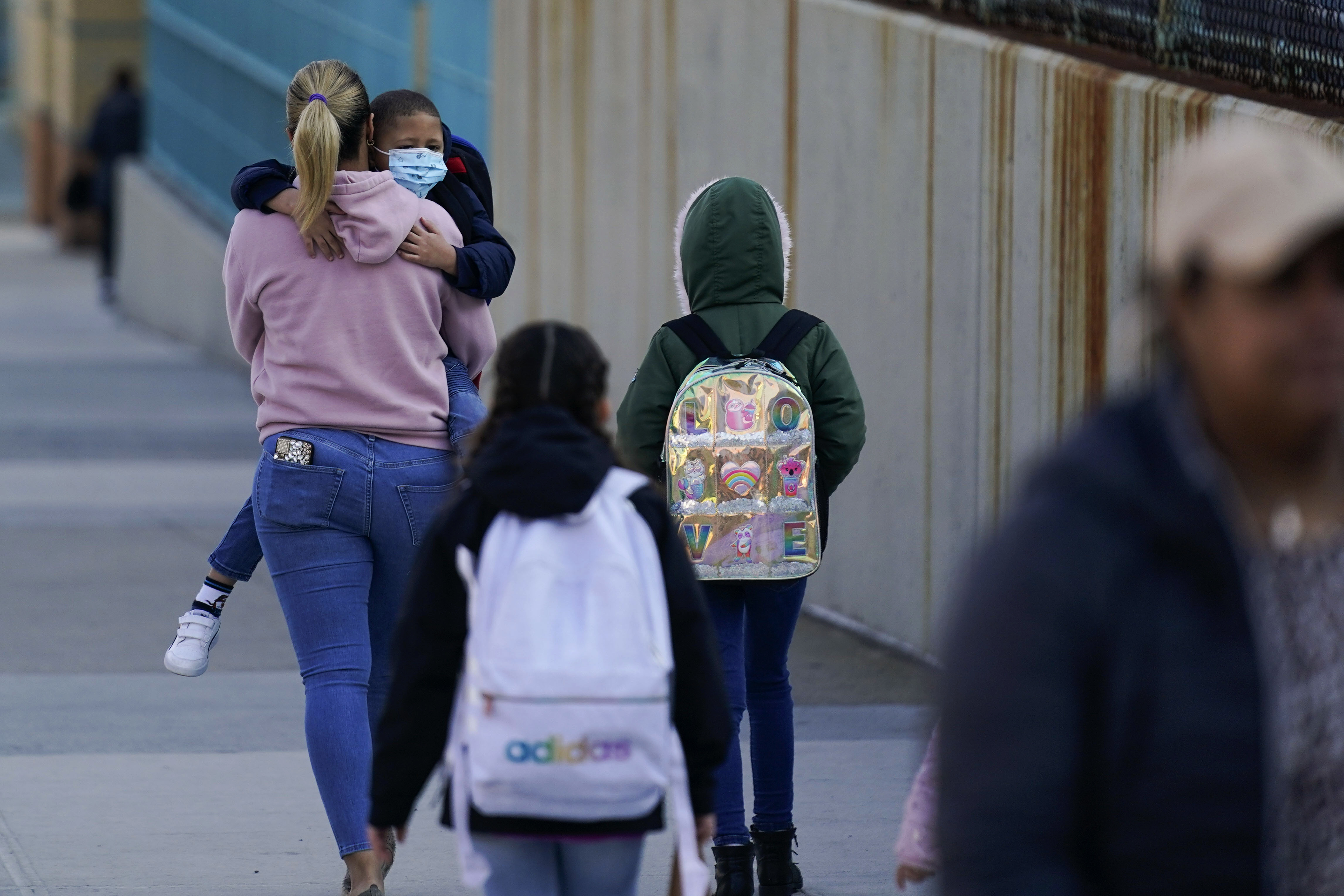 Children and their caregivers arrive for school in New York, Monday. New York City passed a COVID-19 milestone on Monday as masks became optional in city schools and restaurants and other businesses could stop asking patrons for proof of vaccination. 