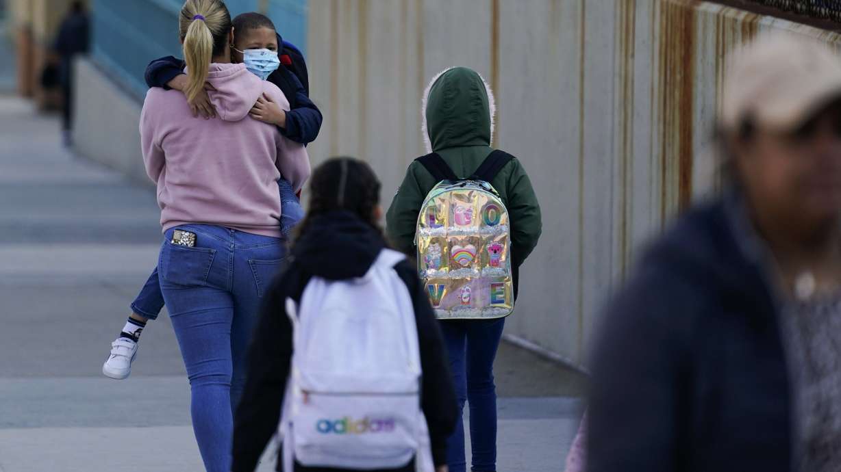 Children and their caregivers arrive for school in New York, Monday. New York City passed a COVID-19 milestone on Monday as masks became optional in city schools and restaurants and other businesses could stop asking patrons for proof of vaccination.