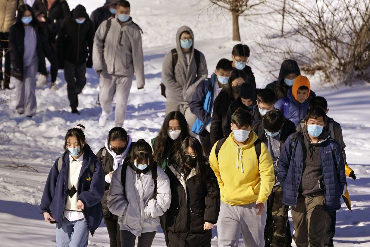 Students, most wearing protective face masks over coronavirus concerns, walk from North Quincy High School at the end of the school day in Quincy, Mass., Feb. 28. Quincy, and many communities around Massachusetts, lifted the mask mandate in schools and on school buses on Monday, but many students kept wearing masks.