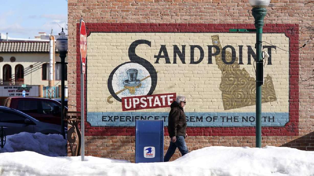 A pedestrian walks past a mural, Monday in downtown Sandpoint, Idaho. The mayor of Sandpoint and many residents worry that the trend of a growing number of real estate companies advertising to conservatives that they can help people move out of liberal bastions like Seattle and San Francisco and find homes in places like rural Idaho is not good for their community.