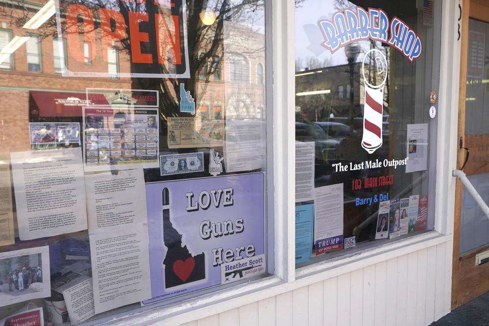 A barbershop displays a sign that reads "Love Guns Here," Monday, Feb. 7, in downtown Sandpoint, Idaho. The sign is a reaction to signs in other businesses that read "Love Lives Here," and are intended to indicate that all are welcome in the community regardless of race, gender, nationality, sexual orientation, or religion, according to the Bonner County Human Rights Task Force,