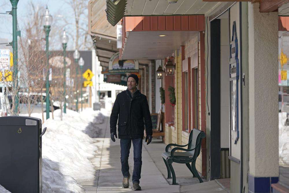 Shelby Rognstad, a Democrat who is Mayor of Sandpoint, Idaho, walks on a sidewalk, Monday, Feb. 7, in downtown Sandpoint. Rognstad, worries that the trend of a growing number of real estate companies advertising to conservatives to find homes in places like rural Idaho is not good for his community.